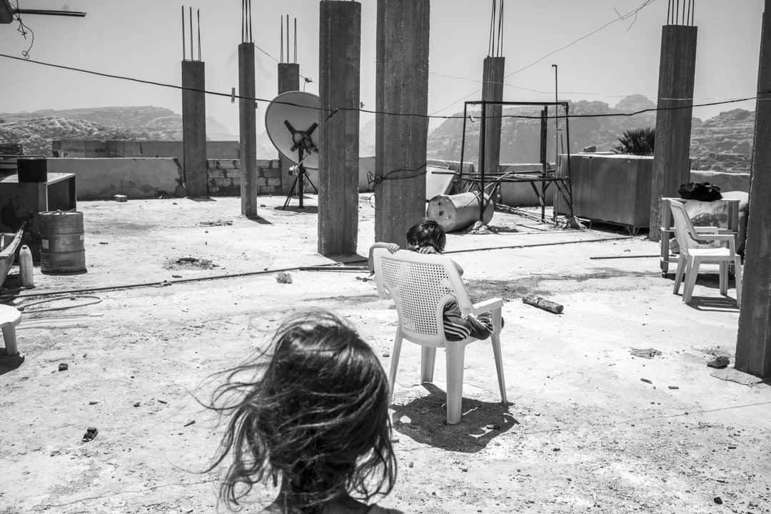 ナショナルジオグラフィックさんのインスタグラム写真 - (ナショナルジオグラフィックInstagram)「Photo by @moisessaman  Bedouin children social distance on the roof of a family home in the village of Um Sayhoun, in Jordan. It's near Wadi Musa, which means Valley of Moses in Arabic. It's said that the prophet passed through the valley and struck water from rock for his followers at the site of Ain Musa ("Moses's Well"). The Nabateans built channels that carried water from this spring to the city of Petra. The tomb of Aaron, the supposed burial site of the biblical Aaron, brother of Moses, is on nearby Mount Hor.  I am not a very religious person, but it seems appropriate to reference the biblical quality of the proportion of this pandemic. Not unlike the plagues described in the Old Testament, the coronavirus has decimated everything in its path, reminding us how small and fragile we are, and what an end of civilization might look like. Inspired by these parallels, I found myself photographing some of the ancient biblical sites in Jordan, searching for allegories that could help make sense of the anxious times we are all living through.」7月13日 11時35分 - natgeo