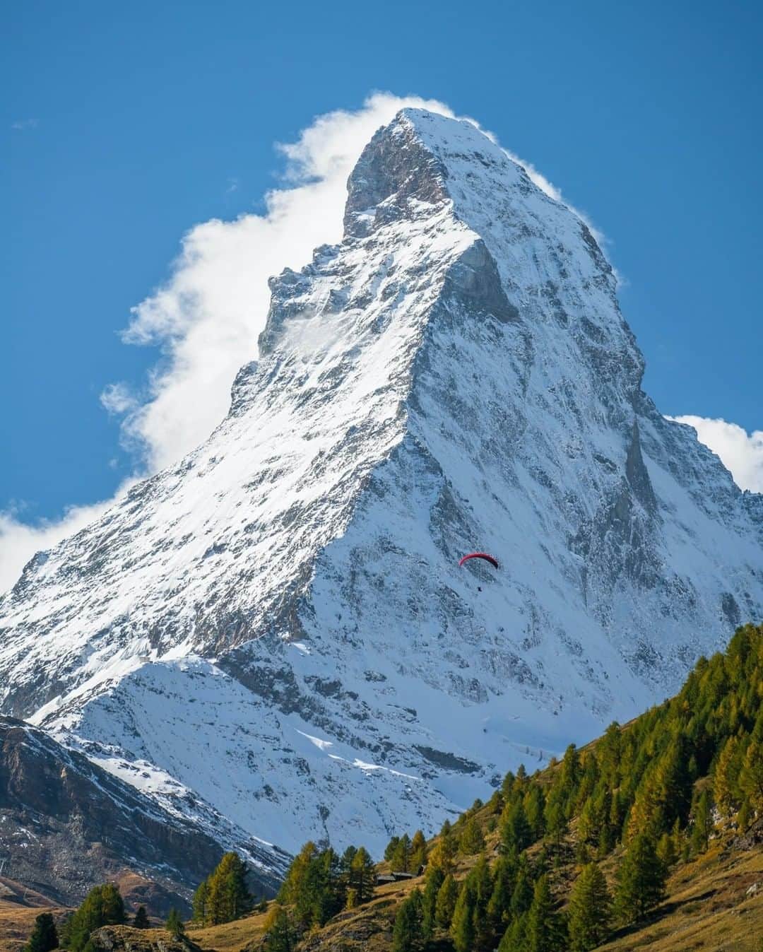 National Geographic Travelさんのインスタグラム写真 - (National Geographic TravelInstagram)「Photo by @chrisburkard  The massive and uniquely shaped peak of the Matterhorn was created by erosion from multiple glaciers diverging from the peak. It has often been referred to as the mountain of mountains and is a symbol for the Alps in general. The Matterhorn is the largest peak in Europe, reminding us how truly small we are in the face of nature.  You can see a lone paraglider in front of the massive face for scale. Paragliding initially began as a military training exercise for paratroopers and has now blossomed into a popular sport in Europe.」7月13日 21時07分 - natgeotravel