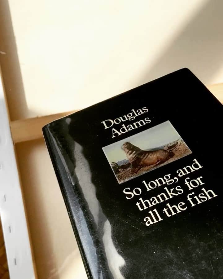 ケンゾーミナミのインスタグラム：「(Book 1 of 7) Douglas Adams “So Long, and Thanks for All the Fish” UK hardcover first edition. With lenticular print of dinosaur and walrus. . The reason why this book comes before the first book “The Hitchhiker’s Guide to The Galaxy” for me is not because it’s the better book, but because when we used to have a broadcast design studio at 83 Canal st, I went to the floor shared bathroom, and someone had left a battered paperback copy of this book there, and I started reading it and couldn’t stop reading but also realized that I was in the middle of the story. (This is the first one with “her” story.) so I went to the book store that day and bought the first book, and the series became my favorite books for my young mind. So this one guided me into the galaxy first. . #solongandthanksforallthefish #thehitchhikersguidetothegalaxy #douglasadams」