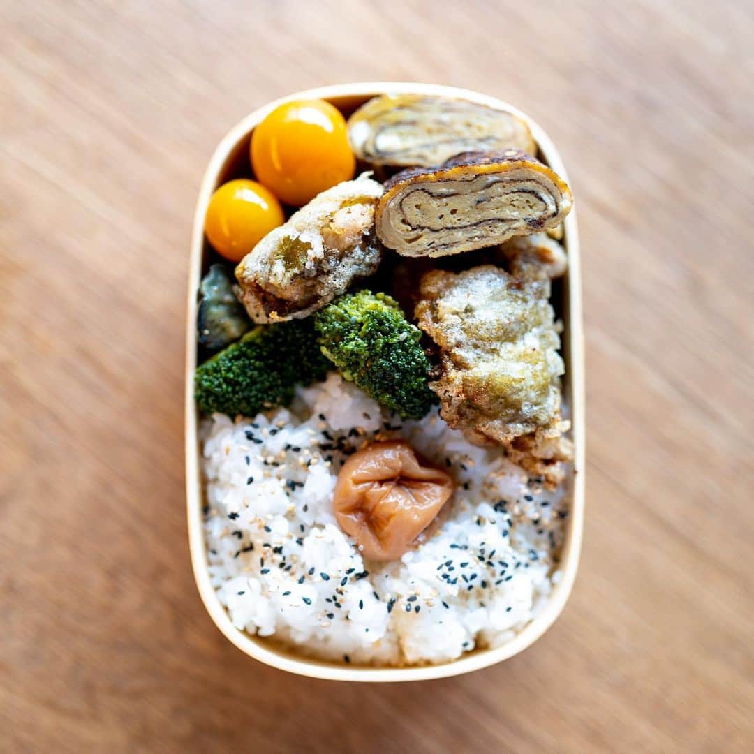 のインスタグラム：「腹が鳴って起床。朝食抜きの16/8 Intermittent Fasting、２日目から危機か？　しかしさすがにそれでは情けない。今日はリモートワークで自宅での原稿仕事なので、いっそ出かけちゃうというワザが使えない。そこでだ、食欲があるときにつくる飯はうまいので、昼の自分のために弁当をつくる。鶏モモを梅酢につけて大葉で挟んで片栗粉をまぶしカリッと焼き、あまじょっぱい玉子焼きをつくり、プチトマトを和風簡易ピクルスに。他の野菜は昨夜の残り。ごはんは冷凍。ああ食べたい、今すぐ食べたいと思いながら写真を撮って、蓋をしました。はみ出てますがね！　さあ13時まで我慢。炭酸水飲もう。原稿を書こう。」