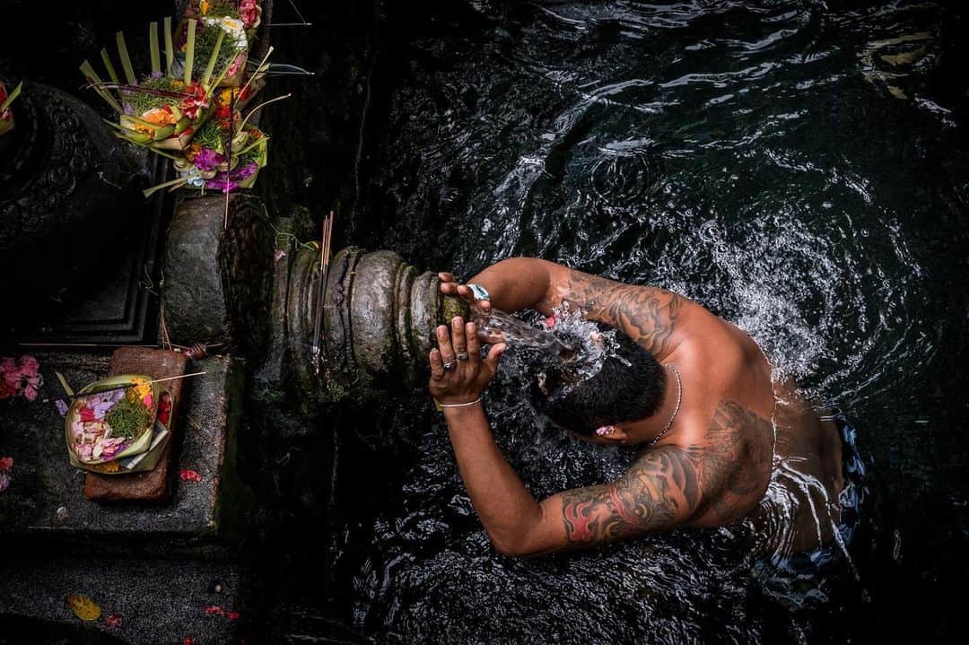 National Geographic Travelさんのインスタグラム写真 - (National Geographic TravelInstagram)「Photo by @francescolastrucci  A pilgrim takes a blessing by one of the fountains of the Pura Tirta Empul (Temple of the Holy Spring). The Balinese visit this place of worship to purify themselves under the sacred waters of the pools, fed by the springs flowing from the side of the sacred mountain. Built in 962 and dedicated to Vishnu, the structure is made up of a set of temples near the village of Manukaya in central Bali. The persistent scent of incense burnt on offer to the gods and the bright colors of the flowers on the fountains make the experience inside the temple highly evocative and mystical. Follow me @francescolastrucci for more places, daily life, and stories around the world. #bali #rituals #dailylife」7月14日 22時42分 - natgeotravel