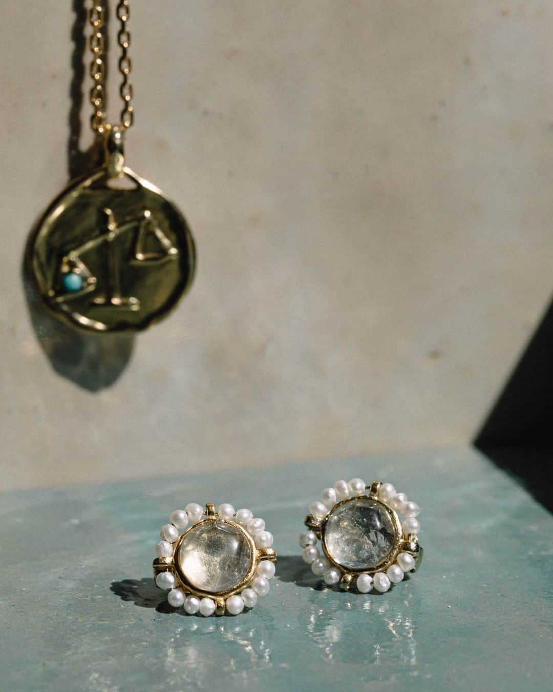 グーセンス パリのインスタグラム：「VENISE earrings, adorned with natural rock crystal cabochons and freshwater pearls and TALISMAN libra mini medal in brass soaked in a 24-carat gold bath, yellow gold color, adorned with a turquoise.」