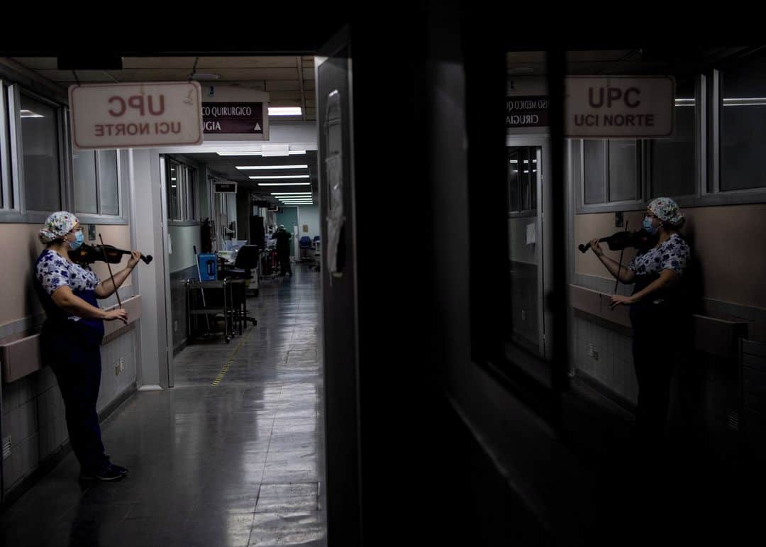 のインスタグラム：「AFP Photo 📷 @martinbernetti_photojournalist - Chilean nurse Damaris Silva plays the violin for patients infected with COVID-19, at the Intensive Care Unit of the El Pino hospital, in Santiago, Chile, on July 9, 2020.」