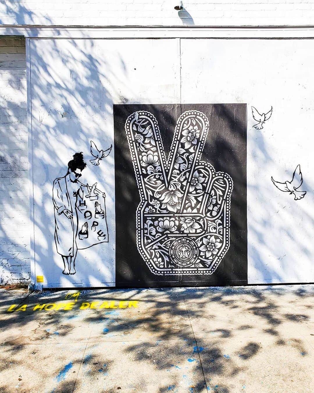 Shepard Faireyのインスタグラム：「Thanks for the great shot, @flipsidemcd! Peace Fingers looks great next to art by @coriemattie. ⠀⠀⠀⠀⠀⠀⠀⠀⠀⁣ I’ve incorporated many different symbols of peace in my work whether its a dove or a tree, or a peace sign. I am pro-harmony and anti-war, but I am also fascinated by the power of easily recognized and reproduced symbols and I continue to explore various icons and the meanings behind them. Objects that represent peace are often beautiful and inspiring to me. -Shepard ⠀⠀⠀⠀⠀⠀⠀⠀⠀⁣ #repost @flipsidemcd #obey #obeygiant #shepardfairey」