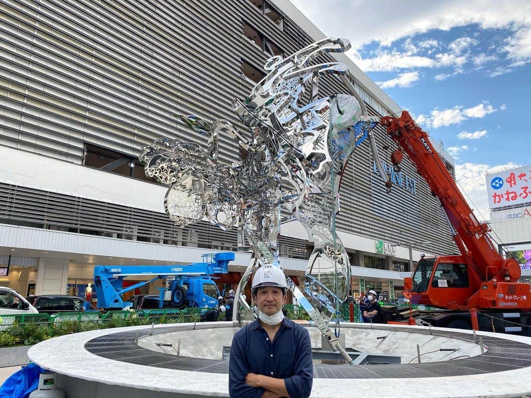 松山智一のインスタグラム：「Happening , now😎 ———- Contemporary Artist, Tomokazu Matsuyama, in collaboration with East Japan Railway Company and LUMINE, launches a new iconic community space at the worlds’ busiest transport hub. The community park space " Shinjuku East Square" will open with its permanent new monumental sculpture and art installation at JR Shinjuku Station in Tokyo from July 19th, 2020  ーーーーーーー  新宿東口駅前広場が大規模パブリックアートで刷新。  株式会社ルミネ(代表取締役社長:森本雄司)は東日本旅客鉄道株式会社(代表取締役社長:深澤祐二)と共同で新宿東口駅前を美化整備する為、気鋭の現代アー ティストとして世界から注目を集める松山智一氏を起用し、パブリックアートを中心とした新宿東口駅前広場を 2020 年 7 月 19 日(日)にオープンいたします。7mを超えるモニュメントを象徴とし、アートに彩られたコミュニティスペースが新たに誕生、広場全体がアート作品となるよう計画されました。  国内外から新宿を訪れる人々の待ち合わせ場所として、また 地元の憩いの場として、この場所からグローカルな交流が生まれる事を目指します。 ------ 完成まで毎日進捗お届けします。」