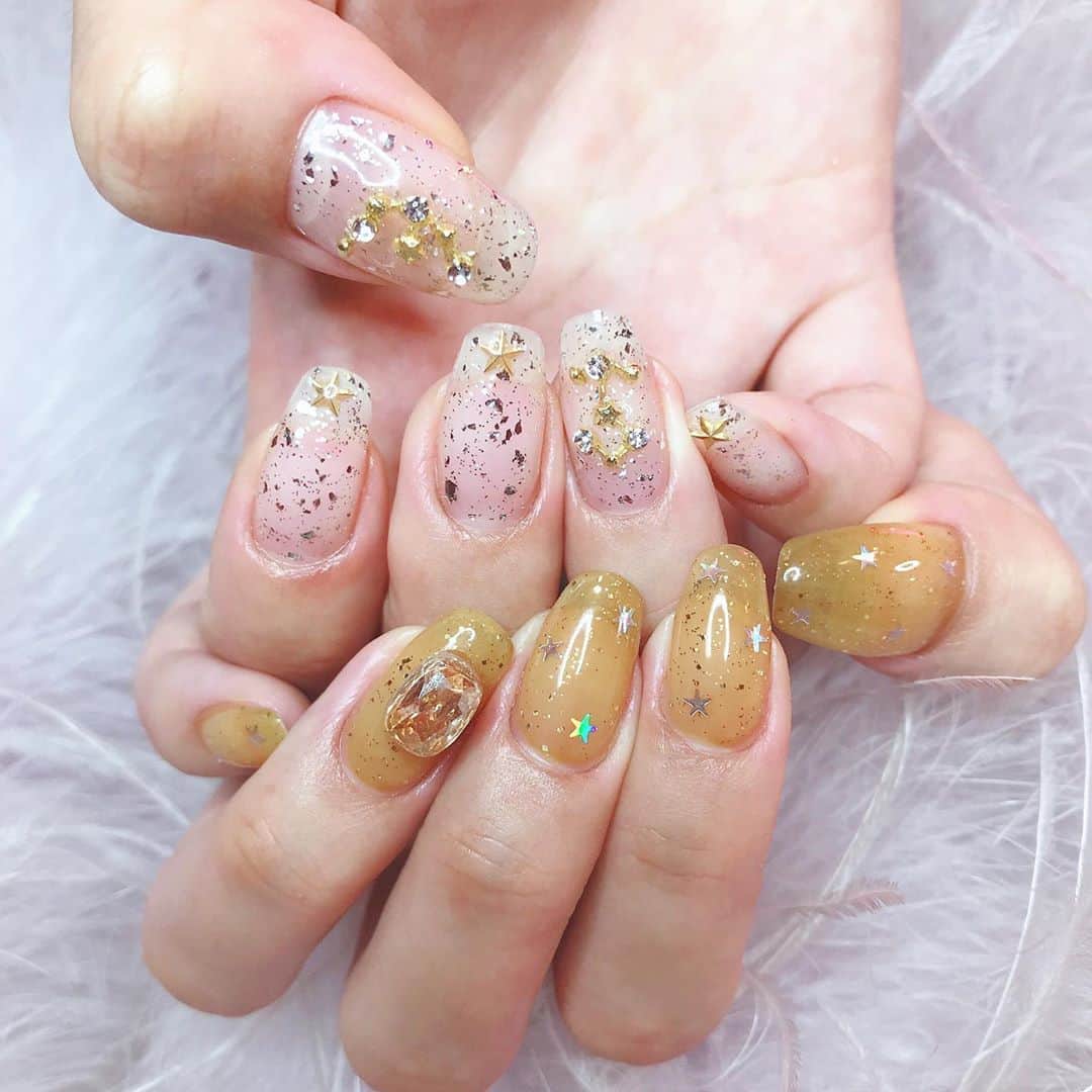 のインスタグラム：「♥️New Nail♥️ 今回は11月生まれをテーマにして、右手は射手座のパーツと(物足りなくて妹の水瓶座のパーツと😂)ゴールドの星を⭐️🏹 左手は11月の誕生石のトパーズをイメージして、オレンジっぽいストーンと、オレンジっぽい透け感のあるベースに星を散りばめたよ🧡✨ めちゃお気に入り💗 かいくんいつもありがとう✌🏻😛 #newnail #nail #pinkrosewindow」