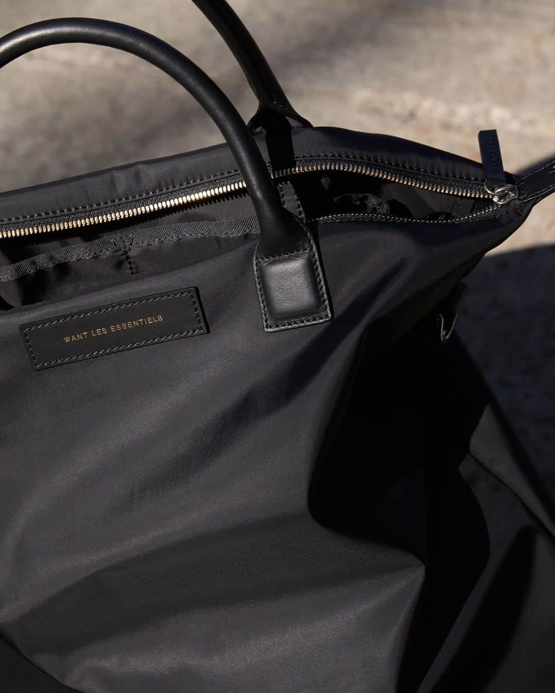 ウォントのインスタグラム：「A minimalist staple. The O'Hare is seen in sleek and durable Italian nylon—then finished with fine leather details.  #wantlesessentiels #oharetote」