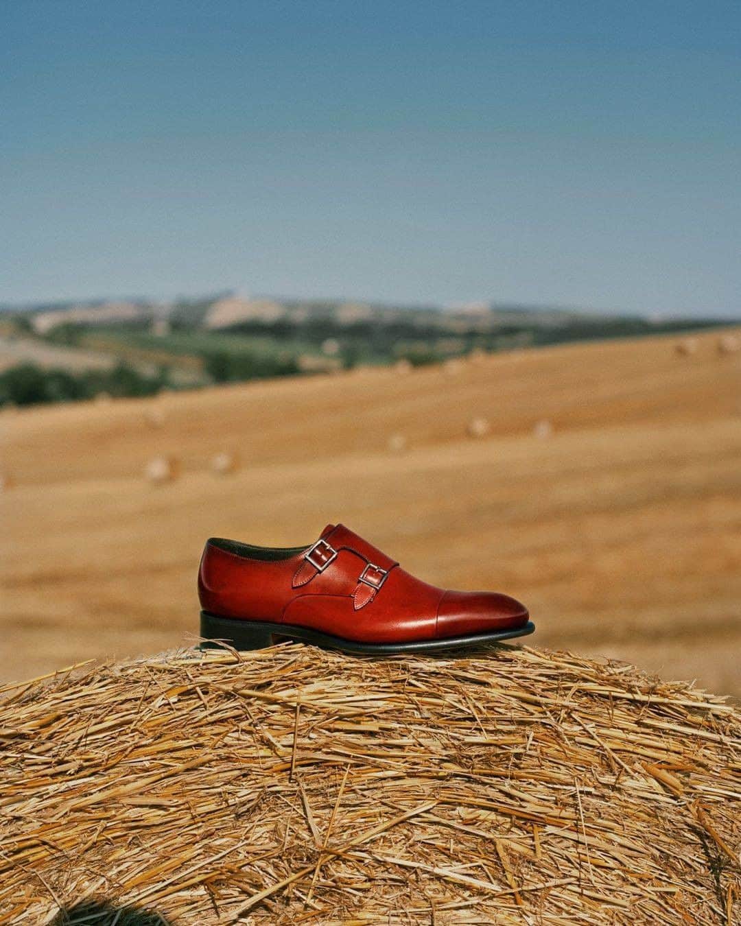 サントーニのインスタグラム：「Entitled “Origini”, our SS21 collection invites you to discover the pure beauty of our homeland. The classic double buckles, icons of the brand, are presented in Morro red, the new nuance introduced in SS21 colour palette.  Creative direction: @socialriseofficial  Photography: @andymassaccesi Styling: @alessiavanini   #Santoni #SantoniSS21 #mfw #MilanDigitalFashionWeek #makersofbeauty」
