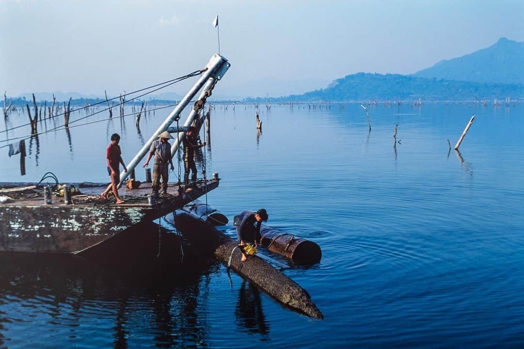 Michael Yamashitaさんのインスタグラム写真 - (Michael YamashitaInstagram)「A former teak forest is reduced to skeletal branches piercing the surface of Nam Ngum Lake. The lake was formed by Laos's first dam built on a Mekong River tributary. Underwater loggers harvest the valuable wood, most of it bound for sawmills in Thailand. Now the question is: will the mighty Mekong be the first of the planet’s great rivers to be destroyed by development?  Dramatic changes to the Mekong’s water flow, caused by climate change and the dozens of dams built over the past 30 years on its upstream reaches in Laos and China, are threatening an ecosystem of unrivalled diversity outside the Amazon. Most are in China, but Beijing denies the dams are impacting down-stream water levels.  As this year's monsoon season gets underway across Indochina, farmers and fishermen along the Mekong are praying for relief from the area's extended drought as the river has seen its lowest levels since record-keeping began 60 years ago. #mekongriver #mekong #namngun #namngumlake #teak #climatechangeart」7月17日 7時33分 - yamashitaphoto