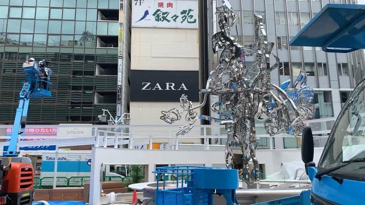 松山智一のインスタグラム：「🎥 🧗🏻🚡🗽 —————- Contemporary Artist, Tomokazu Matsuyama, in collaboration with East Japan Railway Company and LUMINE, launches a new iconic community space at the worlds’ busiest transport hub. The community park space " Shinjuku East Square" will open with its permanent new monumental sculpture and art installation at JR Shinjuku Station in Tokyo from July 19th, 2020  ーーーーーーー  新宿東口駅前広場が大規模パブリックアートで刷新。  株式会社ルミネ(代表取締役社長:森本雄司)は東日本旅客鉄道株式会社(代表取締役社長:深澤祐二)と共同で新宿東口駅前を美化整備する為、気鋭の現代アー ティストとして世界から注目を集める松山智一氏を起用し、パブリックアートを中心とした新宿東口駅前広場を 2020 年 7 月 19 日(日)にオープンいたします。7mを超えるモニュメントを象徴とし、アートに彩られたコミュニティスペースが新たに誕生、広場全体がアート作品となるよう計画されました。  国内外から新宿を訪れる人々の待ち合わせ場所として、また 地元の憩いの場として、この場所からグローカルな交流が生まれる事を目指します。」