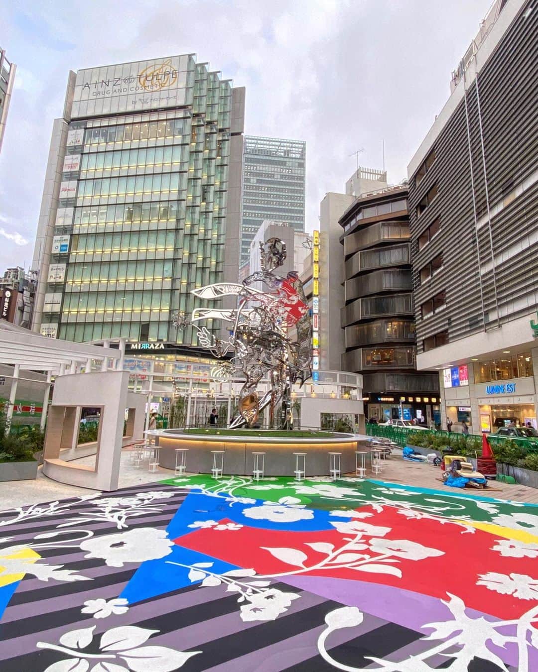 松山智一さんのインスタグラム写真 - (松山智一Instagram)「Complete. newly born Shinjuku East Square. I m honored to have conceptualize the entire square along with my largest sculpture “Hanao-San” the new community space opens tomorrow. And yes it’s permanent.  ————  完成。多くのハードルを乗り越えて２年半かかり実現。 8m のモニュメントともに、広場のコンセプト・デザイン提案させて頂いたプロジェクト。世界最大の駅にこうした公共施設を実現することはあたらしい東京のランドマークになると考え、世界に対しての大きな文化発信に繋がると信じ構想を練ってきた。(株）ルミネ様ならびに(株）東日本旅客鉄道様の文化振興に関する寛容さと柔軟さにこの場をかりて感謝いたします。一芸術家の意見に耳を傾けて頂き、広場のもつ可能性を信じて頂いた関係者皆様に深く御礼申し上げます。 特に今回のプロジェクト進行のキーパーソン、西田香織さん @kaori.nf この場を借りて改めて深く御礼申し上げます。  明日公開。ぜひ一度お運びあれ。ここはアートを見る場所ではない、機能する場所だ！ ーーーーーー アート制作/コンセプト/全体監修:松山智一  施工:安藤ハザマ(株式会社 安藤・間) 設計:デザイン設計、デザイン監修(株)sinato 基本設計、 実施設計(株)JR 東日本建築設計  ディレクション：戸塚憲太郎 #lumineEST #shinjukuStation #HanaoSan」7月18日 12時49分 - tomokazumatsuyama