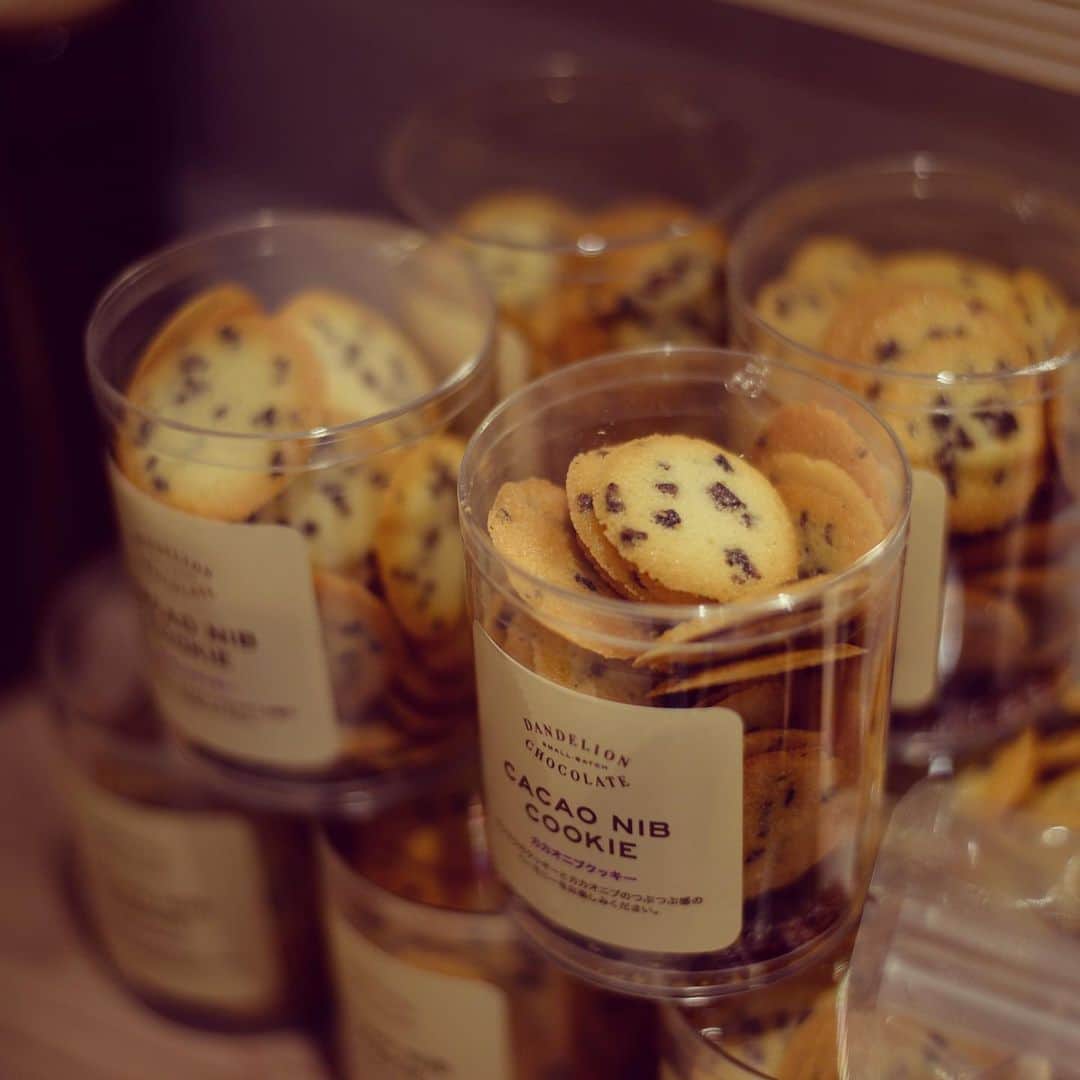 のインスタグラム：「京都店・鎌倉店限定の人気商品だった「カカオニブクッキー(¥600税抜)」が、ファクトリー&カフェ蔵前にて静かに復活しております。  早速、多くのお客さまに連日お買い上げ頂いております。ありがとうございます。  実はこの「カカオニブクッキー」、隠れたベストセラーながら量産ができません。何故ならこのクッキーには、ペストリーシェフ辻舞が通称“2番ニブ”と呼んでいる、出がらしのカカオニブを使用しているからです。  この“2番ニブ”は、ホイップクリームなどに使う生クリームをカカオニブで香りづけする際に生じる、いわば使用済みのニブ。  カカオニブクッキーの薄くて繊細なラングドシャ生地には、出がらしのニブがちょうど良く、カカオの香りも調和され、優しく寄り添ってくれるのです。  しかもこの“2番ニブ”、再利用するには結構な手間がかかります。  生クリームに香り付けした後に残るものなので、ニブに付着しているクリームをザルを使用し流水でよく洗い、さらにオーブンで低温にてよく乾燥させたものを使用しています。  ここまでして再利用するのには、貴重なカカオ豆を最後の最後まで丁寧に使い切りたいという気持ちが込められています。  ニブに限らず、あらゆる原材料に対しても、地球から頂く豊かな恵みに常に感謝しながら、最後の一粒まで大切に美味しく頂く工夫をしていきたいものです。  そんな思いが詰まった「カカオニブクッキー」、是非一度召し上がって頂ければ幸いです。  #ダンデライオンチョコレート  #カカオニブ #クッキー  #カカオニブクッキー  #ラングドシャ #食の知恵は一生の宝物 #もったいない」