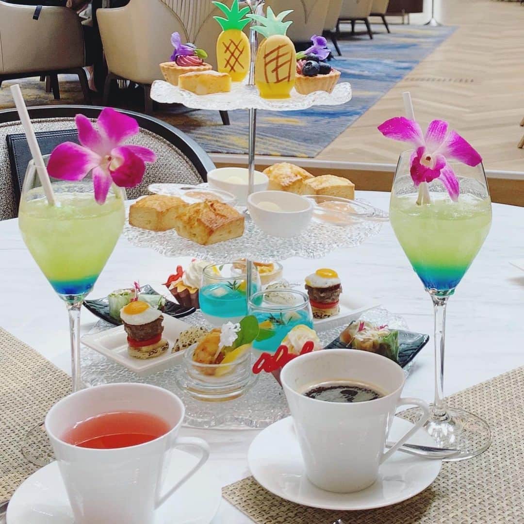 のインスタグラム：「品川駅直結のストリングスホテル のアフタヌーンティー。  ハワイ🌴をテーマにアロハ・アフタヌーンティー。  パインのマカロンにセイボリーのエビ、ミニライスバーガーetc...  カクテルジュース🍹もついて、ハーブティーもお替わりできます。  今年は海外旅行は難しいので、  ハワイ気分ならホテル で。。  コロナウィルス感染予防も体温チェックありの安心対応。  距離を取り、横並び座席。  ガイドラインに則していますね。  企業努力に感謝です。  ロケ対応でフェイスガードもゲット！！  しかし、息で曇る、、、😭  お仕事でも安心していただけるように、精進いたします。  #ストリングスホテル東京インターコンチネンタル #アロハアフタヌーンティー#ハワイ気分#ホテルスイーツ #ホテルスイーツ巡り#アフタヌーンティー#sweets# ストリングスパフェ」