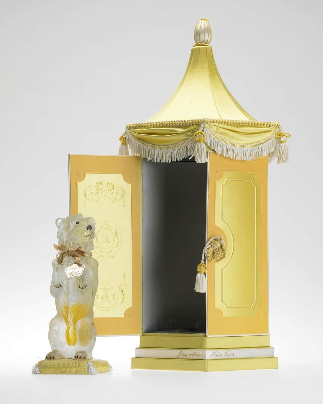 クリスチャンディオールさんのインスタグラム写真 - (クリスチャンディオールInstagram)「Building on the repeat success of the various 'Bobby' couture daywear creations, Monsieur Dior's beloved pet inspired a special edition of the legendary 'Miss Dior' perfume in 1952, with a precious dog-shaped bottle designed by Fernand Guery-Colas. Initially named 'Le Bobby de Miss Dior', it was ultimately launched as 'J’appartiens à Miss Dior' ('I Belong to Miss Dior') in an extremely limited edition. Adorned with an inscribed dog tag, each numbered bottle was presented in an elaborate yellow satin 'pagoda niche', as depicted here being received by the Begum Aga Khan at a gala dinner held during the 1954 Festival de Cannes.  #DiorHeritage  © Collection Christian Dior Parfums」7月19日 1時00分 - dior
