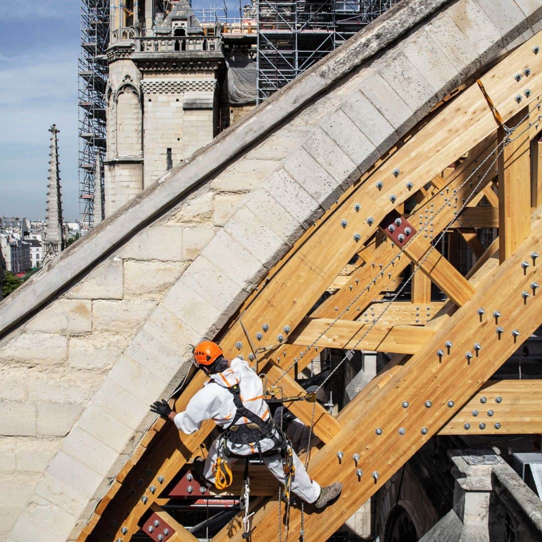 ルモンドさんのインスタグラム写真 - (ルモンドInstagram)「Jusque-là, Notre-Dame avait connu trois mois d’intense folie. En quelques jours, un premier bataillon d’ouvriers, de techniciens, de scientifiques avait accouru à son chevet pour tenter de sauver le chef-d’œuvre en péril. Le 25 juillet 2019, l’inspection du travail siffle la fin de la partie. Crachées par la toiture et la flèche, 200 tonnes de plomb se sont disséminées partout, du haut de l’échafaudage au pied des piliers, en coulées ou en poussières, spectaculaires ou invisibles. Les niveaux relevés et le dispositif sanitaire établi mettent en danger la santé des intervenants, tranche l’inspection. Le risque de contamination est double : par ingestion ou inhalation. La fermeture du chantier cueille toute l’équipe par surprise.⁣ Près d’un mois d’arrêt forcé, des équipes à remobiliser et de nouvelles règles, beaucoup plus tatillonnes. Formation pour tous (même les journalistes), équipements imposés (combinaison, masque, charlotte), procédures minutieuses (douche à chaque passage entre l'église et la base vie).⁣ Avant le 25 juillet 2019, charpentiers, grutiers et cordistes ont posé, en trois semaines, la moitié des vingt-huit cintres de 16 mètres de long et 8 tonnes, destinés à soutenir les arcs-boutants. Une étape. Mais pour stabiliser la rescapée, il faut en franchir bien d’autres : poser un plancher en haut des murs pour lester l’édifice ; installer d’immenses équerres pour sécuriser les pignons ; corseter deux colonnes, endommagées par la chute de la flèche en feu. Des manœuvres aussi périlleuses pour l’église que pour les compagnons qui s’affairent, à 40 mètres au-dessus du sol, au milieu de tonnes de pierres fragilisées.⁣ -⁣ 1 : Un cordiste installe l’un des vingt-huit cintres en bois pour soutenir les arcs-boutants sur le chantier de la cathédrale Notre-Dame de Paris, le 22 juillet 2019.⁣ 2 : Des ouvriers se changent avant d’entrer dans la zone « souillée » du chantier de la cathédrale Notre-Dame de Paris, le 7 octobre 2019.⁣ Photos : Patrick Zachmann (@pzachmann) / Magnum Photos (@magnumphotos)⁣ -⁣ #france #societe #culture #patrimoine #notredame #cathedrale #incendie」8月13日 16時21分 - lemondefr