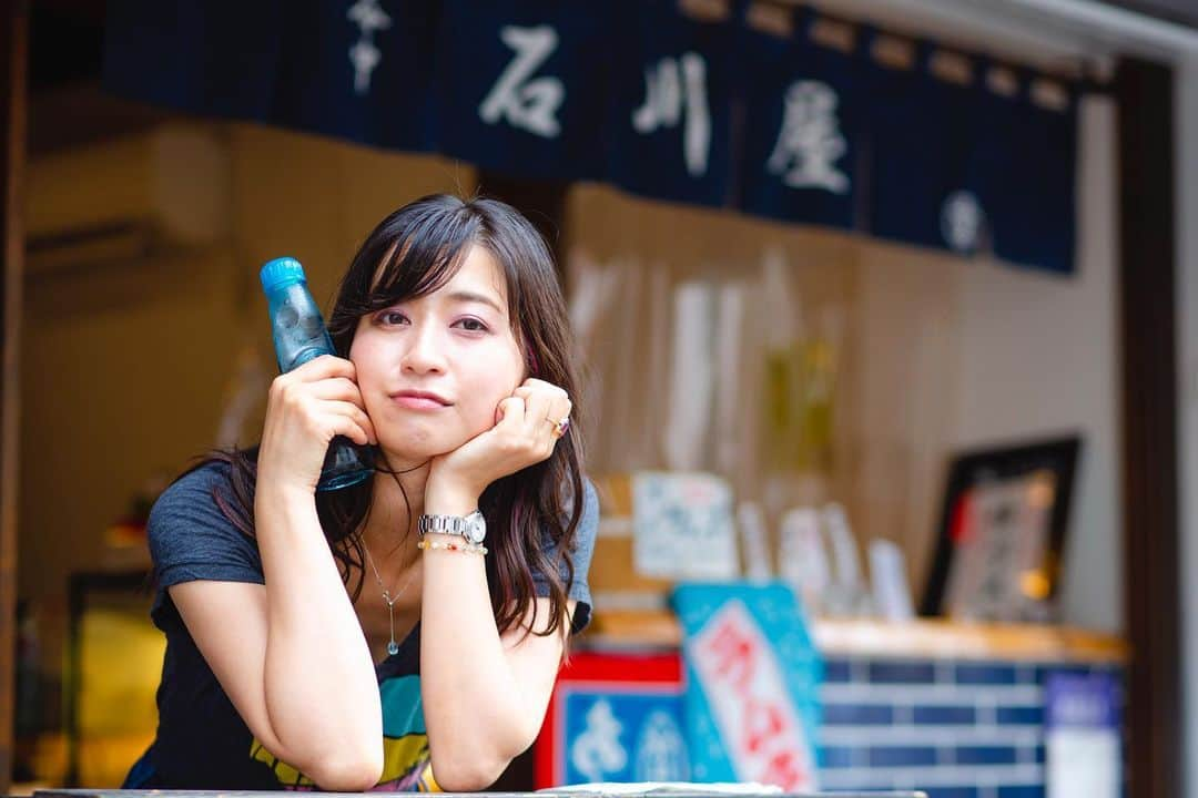 今井安紀のインスタグラム：「Taken by @ishiihiroko .  I went Yanaka, Tokyo with Hiroko-chan. We found a store that sold old-fashioned soda pop. It was really nostalgic.  ひろこちゃんと夏の谷中散歩。 プラプラ歩いていたらラムネの看板を見つけて「飲んじゃう？飲んじゃう！」と子供のようにはしゃぎながらお店へ。 このラムネ、1896年からある日本最古のラムネメーカーさんのなんだって。懐かしい味と清涼感、谷中の雰囲気も相まってあっつい日のお散歩にぴったりでした。 ラムネ瓶をマイクにして歌ってるみたいなのが1枚紛れているのは気のせいだろうか……！ 帰りがけ「ビー玉綺麗だから持っていきなさい」と瓶から取り出してくださったので、ついついはしゃいで撮影していると「実はこれ、ビー玉じゃなくてエー玉なのよ。ラムネ瓶に使えるのがA玉、使えない規格外がB玉なの」と豆知識まで教えていただきました。  撮影OKして椅子まで出してくださった石川屋さん @ishikawaya_yanaka ありがとうございました。また寄ります。  #summergirl #summerlady #soda #sodapop #bead #glassball #yanaka #yanakaginza  #夏女 #夏娘 #ラムネ #谷中 #谷中散歩 #ビー玉」