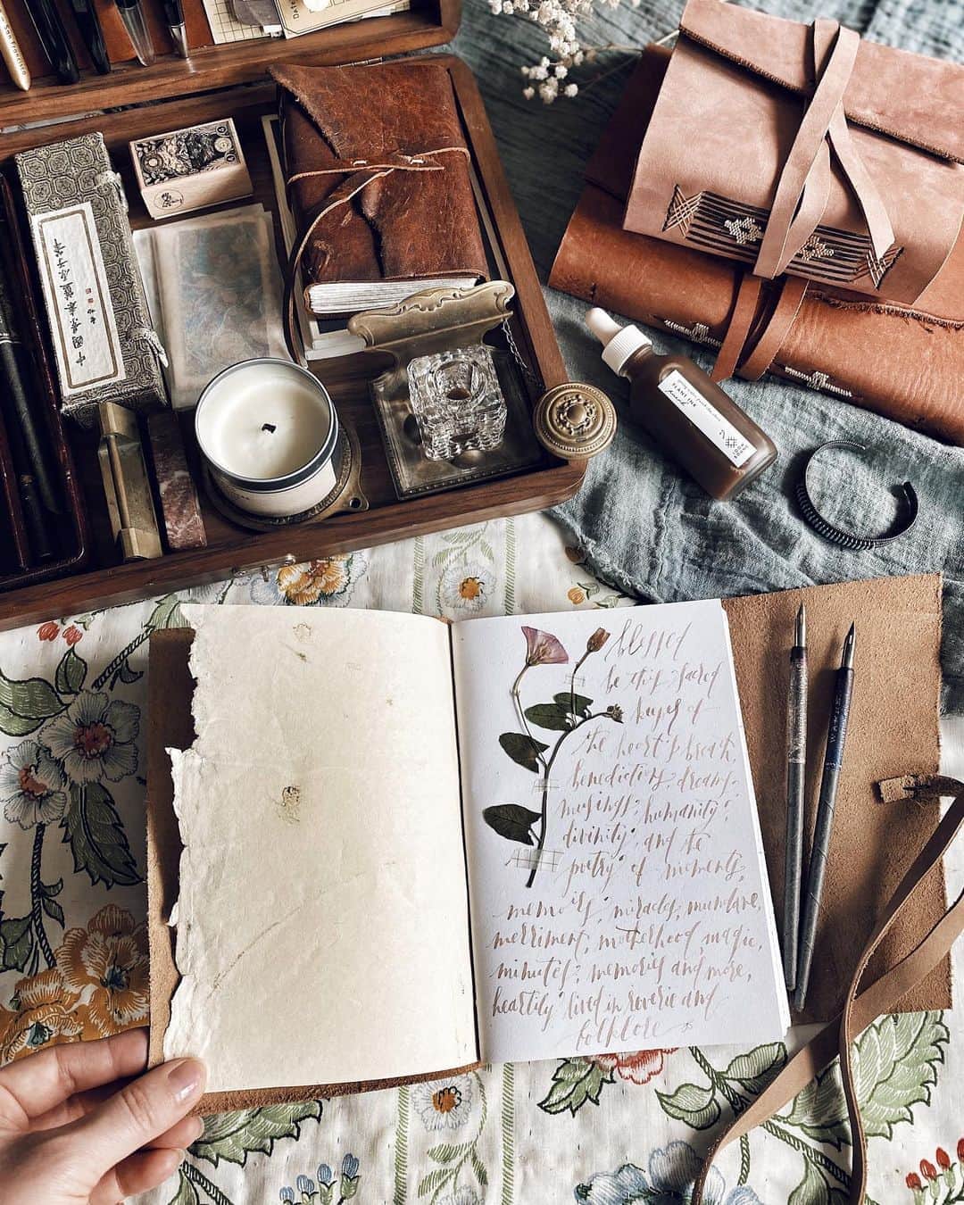 Catharine Mi-Sookさんのインスタグラム写真 - (Catharine Mi-SookInstagram)「Desks and tables a plenty but preferred are the unconfined expanse of quilted bed tops and floors with relics of olde and new in tow, each holding stories and memories and magic. . It’s been a heavy week. Grief is an uninvited guest crashing the party with its weight crushing shock and loss. Yet in its paradoxical juxtaposition of life and death, if embraced, it somehow carries us through and back into life, back into living, and somewhere in the loss is an exchange, a gift imparted, though if I am honest, I still grit my teeth somewhere in there for which I hold no remorse as it is but a testament of a heart that embraces fully and wholly. And yet it is worth it, always, through and through. . I imagine this season has held an element of that heavy weight in some form and semblance for all. Sweeping changes and shifts, constant pivots and unknowns. It’s a lot. Somewhere in this saunter through brambles and beauty I have learned to give myself grace, and to be honest with my heart, truly and unapologetically so, and in turn adjust my veerings to be congruent with those very truths. I have learned to let go and shut doors, and I have also learned to embrace peace in new ones opened. It is okay to grow and outgrow. It is okay to change and keep changing. It is okay to get muddy along the way. And it is more than okay to take pauses, to relish in small and big joys alike, and to make plenty of room for beauty. I’m making extra room for just that, for joy and laughter, for pauses and beauty in between, and wishing you all much the same too. . . . #journaling #memoirs #loombound #handmadebook #bookbinding #handmadejournal #writinglife #poetryoflife #galenleather #writingbox #stationerylove #loveforanalogue #dippen #quillandarrow #leatherjournal #thedailywriting #flatlaystyle #flatlayphotography #flatlayoftheday #creativespace #slowlivingforlife #handsinframe #journalcommunity #dailyjournal #hyggelife #petalsandprops #theartofslowliving」8月15日 2時30分 - catharinemisook