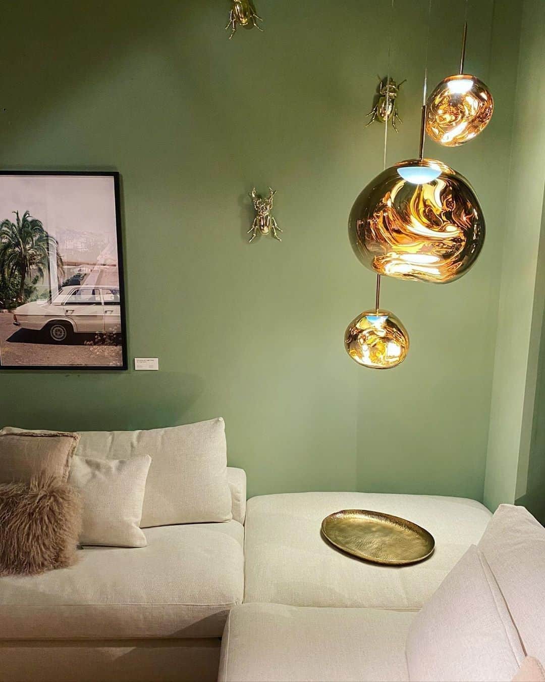 のインスタグラム：「One of @decor.amsterdam's cosy corners in their interior showroom, with three MELT LED pendants in Gold.⁠ ⁠ For MELT we have taken vacuum thin film deposition to a new level with half metallised surfaces, creating an extraordinary optical effect that reflects and enhances its environment. ⁠ ⁠ This half-mirrored effect often seen on a smaller scale in fashion sunglasses or gangster windscreens transforms into a translucent colour when switched on.⁠ ⁠ Read more via the link in bio. ⁠ ⁠ ⁠ #tomdixon #tomdixonMELT #lighting #interior #design #interiordesign #spaces #instaspaces #instahome #inspiration #ideas #greenandgold #metallised」