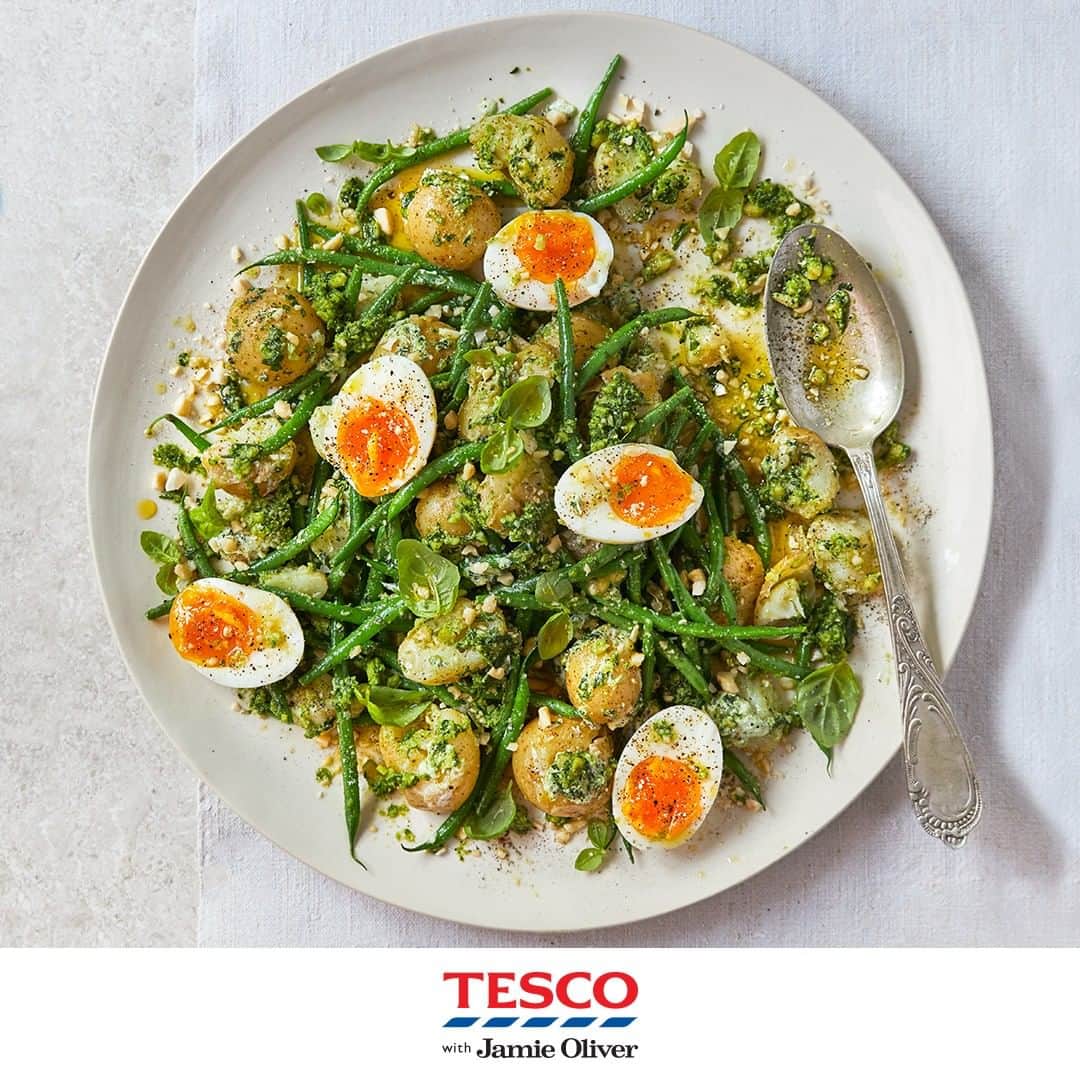 Tesco Food Officialさんのインスタグラム写真 - (Tesco Food OfficialInstagram)「A simple salad for summer evenings, courtesy of @JamieOliver. Try this as a light dinner or BBQ side, that’s the perfect way to #EatMoreVeg. #TescoAndJamie  Ingredients: 750g baby new potatoes 220g fine green beans 3 large free-range eggs 1 bunch of fresh basil (30g) 1 small garlic clove 40g blanched almonds extra virgin olive oil 40g Cheddar 1 lemon 2 tbsp natural yogurt  Method: 1. Scrub the potatoes, halving any larger ones, then cook in a large pan of boiling salted water for 25 mins, or until tender.  2. Gently lower in the eggs to cook with the potatoes for the final 7 mins.  3. Line up the beans, trim off just the stalk end, then boil in the water with the potatoes and eggs for the final 4 mins, or until just cooked but not squeaky. Drain the potatoes, eggs and beans in a colander, pick out the eggs, then leave the potatoes and beans to steam dry. Refresh the eggs under cold water until cool enough to handle, then peel and cut in half.  4. For the pesto, pick most of the basil leaves into a pestle and mortar (reserving a few for garnish) and bash to a paste with a pinch of sea salt. Peel and bash in the garlic, then pound in most of the almonds until fine. Muddle in 2 tbsp of oil, finely grate in the Cheddar, along with a good fine grating of lemon zest and a squeeze of juice, then stir.  5. Scrape the pesto into a large bowl, stir through the yogurt and season to taste. Tip in the hot potatoes and beans, then fold them through the pesto sauce, smashing up some of the potatoes as you go for texture.  6. Tip the potatoes onto a platter, arrange the eggs over the top, then bash up the remaining almonds and scatter over. Finish with the reserved basil leaves and an extra drizzle of oil.」7月24日 19時00分 - tescofood