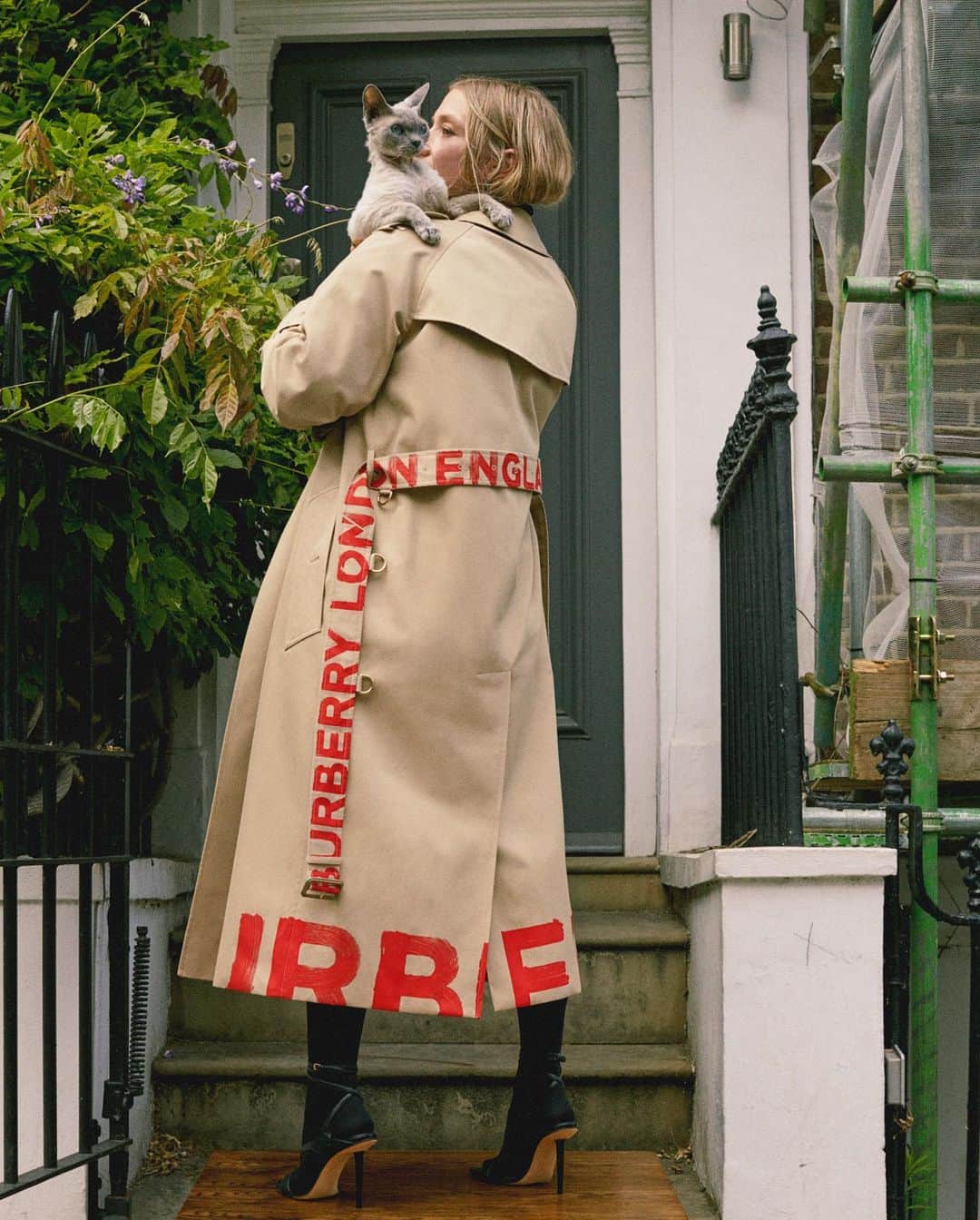 Burberryさんのインスタグラム写真 - (BurberryInstagram)「Sabrina, Accessories Design, Notting Hill . Discover the Spring/Summer 2021 pre-collection lookbook - a celebration of the #Burberry community, inspired by Thomas Burberry’s legacy of discovery and the great outdoors . Photographed outside her London home, Sabrina wears our bespoke gabardine trench coat and oversized shirt with graffitied logo prints, technical wool gabardine longline shorts, engraved bangles and wraparound sandals . #BurberryPreSS21」7月24日 19時32分 - burberry