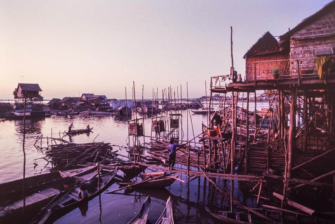 Michael Yamashitaさんのインスタグラム写真 - (Michael YamashitaInstagram)「Kampong Chnang stilt village, built to withstand the 30-foot rise and fall of the Tonle Sap (Great Lake) between wet and dry seasons. This is the largest freshwater lake in Southeast Asia and the only waterway in the world that actually changes direction twice a year. During the wet season, June through October, excess water flows northward upriver into the lake, swelling it to five times its size. Come the dry season, November to May, the river reverses its flow gradually draining the lake, naturally regulating the water that reaches the delta in the south, keeping it constantly supplied throughout the year. I climbed up and through this labyrinth of bamboo stilt houses, some as tall as three stories, in search of the perfect sunset.  But the Tonle Sap is in serious trouble. Drought, dam building and overfishing have brought it to a tipping point. As the lake goes, so goes the greater Mekong ecosystem. A devastating drought last year left the Mekong River at its lowest level in recorded history. And as the Mekong goes, so goes the Tonle Sap, as well as the livelihoods of the fishermen who live here in this amazing architectural wonder. Pray for rain. #tonlesaplake #stilthouse #stiltvillage #tonlesap #cambodia #climatechange」7月28日 0時34分 - yamashitaphoto