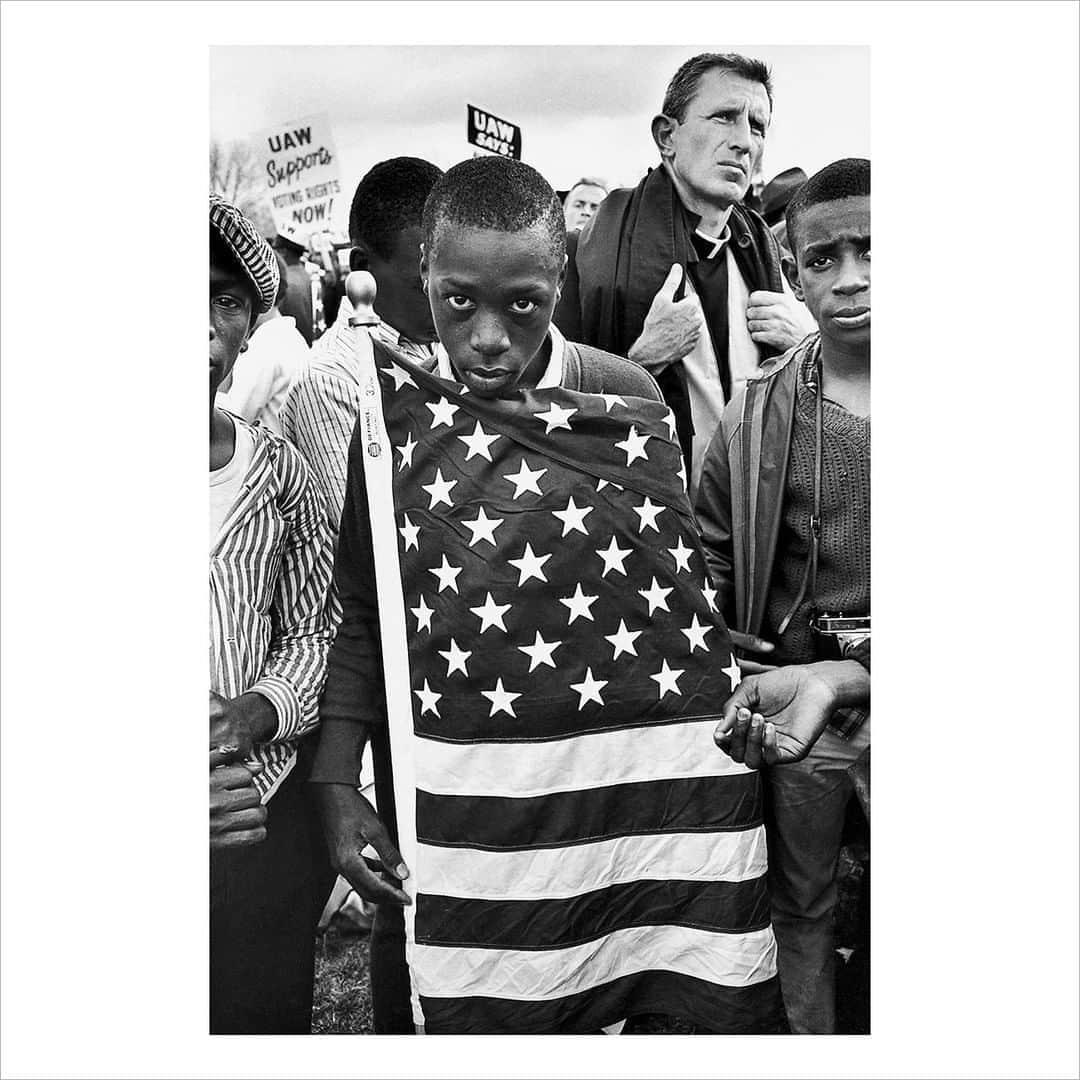 Magnum Photosさんのインスタグラム写真 - (Magnum PhotosInstagram)「“This photograph was taken during one of the 1965 protest marches from Selma to the Alabama State Capitol in Montgomery. Martin Luther King Jr. led a group of African-American, non-violent marchers to exercise their constitutional right to vote, in defiance of segregationist repression. This was a watershed moment in the U.S. civil rights movement. I came across this young demonstrator, wrapped in a flag, protesting racism; behind him is Father Sherrill Smith of San Antonio, a white catholic priest who protested against injustice for most of his life.” – Bruce Davidson⁠ .⁠ Solidarity, the July Magnum Square Print Sale, in support of the @naacp and in collaboration with @voguemagazine, is live for 1 week only!⁠ .⁠ This is a unique opportunity to purchase signed or estate-stamped prints by over 100 of the world’s leading photographic artists in an exclusive 6x6” format for $100.⁠ .⁠ Magnum photographers and Vogue are both donating 50% of their proceeds to the National Association for the Advancement of Colored People (@naacp), the longest-running, and largest civil rights organization in the United States.⁠ .⁠ The NAACP’s mission is to eliminate race-based discrimination and uphold equality of rights of all persons.⁠ .⁠ Visit the link in bio to see all the images available.⁠ .⁠ PHOTO: Protest March from Selma to Montgomery. Alabama, USA. 1965. ⁠ .⁠ © @brucedavidsonphoto/#MagnumPhotos⁠ ⁠ #MAGNUMSQUARE #Solidarity #printsale」7月29日 18時01分 - magnumphotos