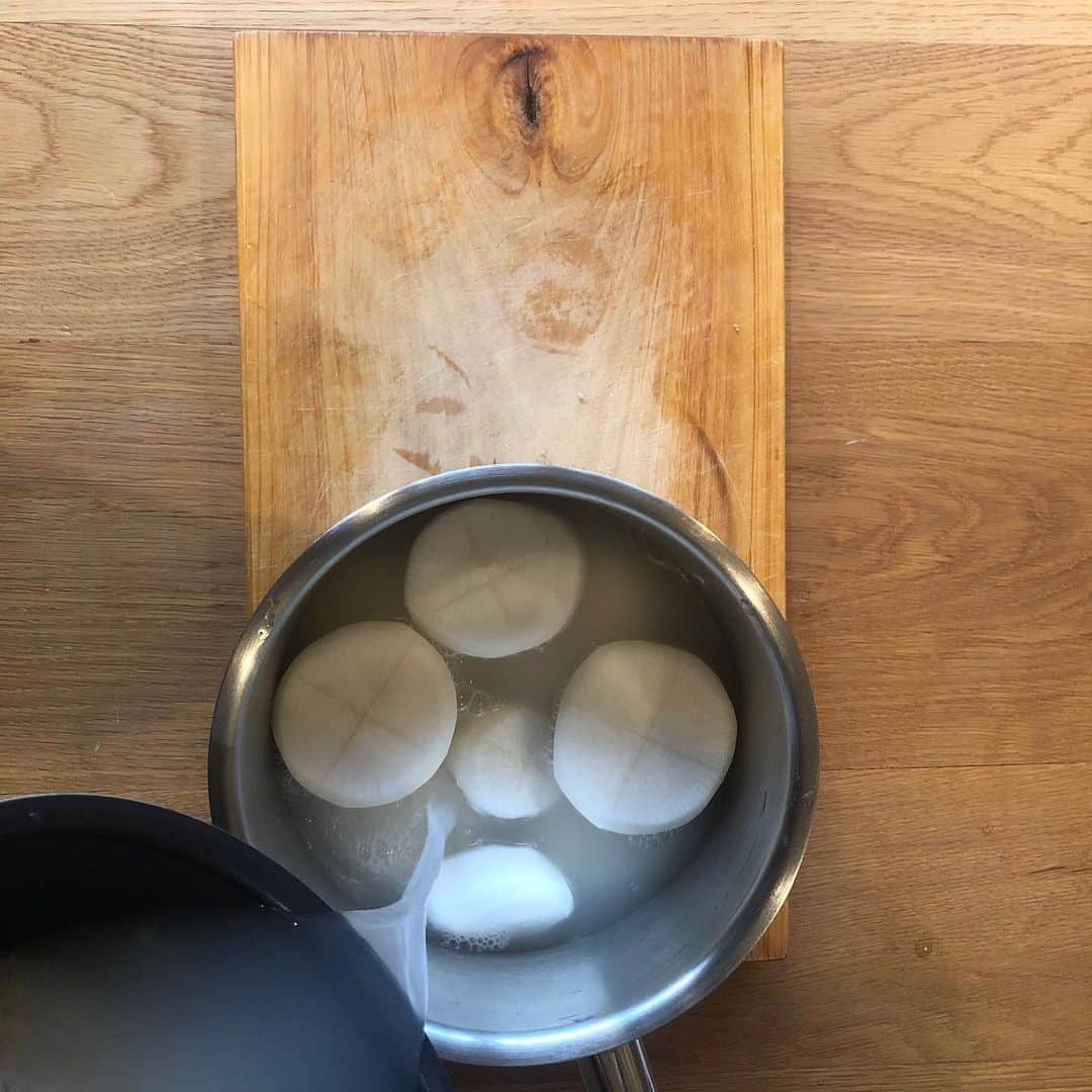 森美術館さんのインスタグラム写真 - (森美術館Instagram)「🍴 ARTISTS COOKBOOK BY MAM レシピ#12 アキラ・アキラ「大根の煮物」 現在地：シェパートン（オーストラリア）  海外生活20年を超えるアキラ・アキラ。作品に見られる細部へのこだわりは、異国で作る日本の基本料理にも。見えないところの工夫、隠し包丁は日本の美学です。そして、森美術館のシリーズ展「六本木クロッシング」が、ニュージーランド、ニュー・プリマスでの繋がりを生んでいるのも嬉しいストーリー。  • 料理にまつわるストーリー ニュージーランド北島のニュー・プリマスに住んでいた頃、キュレーターである私のパートナーが、プロジェクトで一緒になったアーティストたちをもてなすのによく料理をしていました。ニュー・プリマスは少し辺鄙な場所にあり、アーティストは皆、遠方からはるばる時間をかけて来てくれるので、滞在初日の夜には自宅に招き、私が彼らのために栄養たっぷりの料理を作ってあげるのが習慣になりました。この「典型的な」日本食を、毛利悠子さん（「六本木クロッシング2016展」参加）や、田村友一郎さん（「六本木クロッシング2019展」参加）などアーティストのために料理するのは、私の楽しみでした。この一皿は田村さんを唸らせ、私が食堂を開けるとまで言ってくれたのです！  • 所要時間 2時間強⏱  • 材料 大根 米のとぎ汁（または、水＋小さじ1杯程度の生米） 出汁 150 ml　（作り方は以下を参照） 粗糖 大さじ1杯 みりん 大さじ1杯 薄口醤油 大さじ2杯 和からし  • レシピ 出汁を作るには、まず、小鍋に700 mlの水に対して7 グラム程度の昆布を入れ30分ほど放置したあと、弱火にかける。沸騰する直前で火を止め、鰹節をひとつかみ足したら、再度中火にかけ、沸騰させたら火を弱め4分ほどコトコト煮立てたら、火を止める。冷ましたら濾し、出来上がり。お味噌汁にも使えます。  ＜大根の煮かた＞ 1. 生の大根を3センチ程度の厚さに輪切りし、周りの皮をむく。 2. それぞれの角を綺麗に面取りする。  3. それぞれ両面とも、中心に深さ5ミリ程度の切れ目を十字に入れる（隠し包丁）。  4. 小鍋に輪切りにした大根を入れ、少し温めた米のとぎ汁で大根を覆う（これが大根を柔らかく煮るコツ）。とぎ汁がない場合は、小さじ1杯程度の生米と水で代用する。  5. 1時間半ほど煮たら、大根から水気を切り、鍋は洗う。  6. 大根を洗った鍋に戻し、今度は水を大根がかくれるくらい入れる。20分ほど煮立てたら、再度水を切る。  7. 出汁を加えたら火にかけ、とろ火で煮る。  8. 砂糖を加えて溶けたら、みりん、そして薄口醤油を加える。味見をして調整。  9. とろ火で再度、大根の色が一緒に煮ている水分と同じ色になるまで静かに煮たら、出来上がり。和からしを添えてテーブルに。🙂  #ArtistsCookbookByMAM #AkiraAkira #MoriArtMuseum #MuseumFromHome #Cookbook」7月29日 23時30分 - moriartmuseum