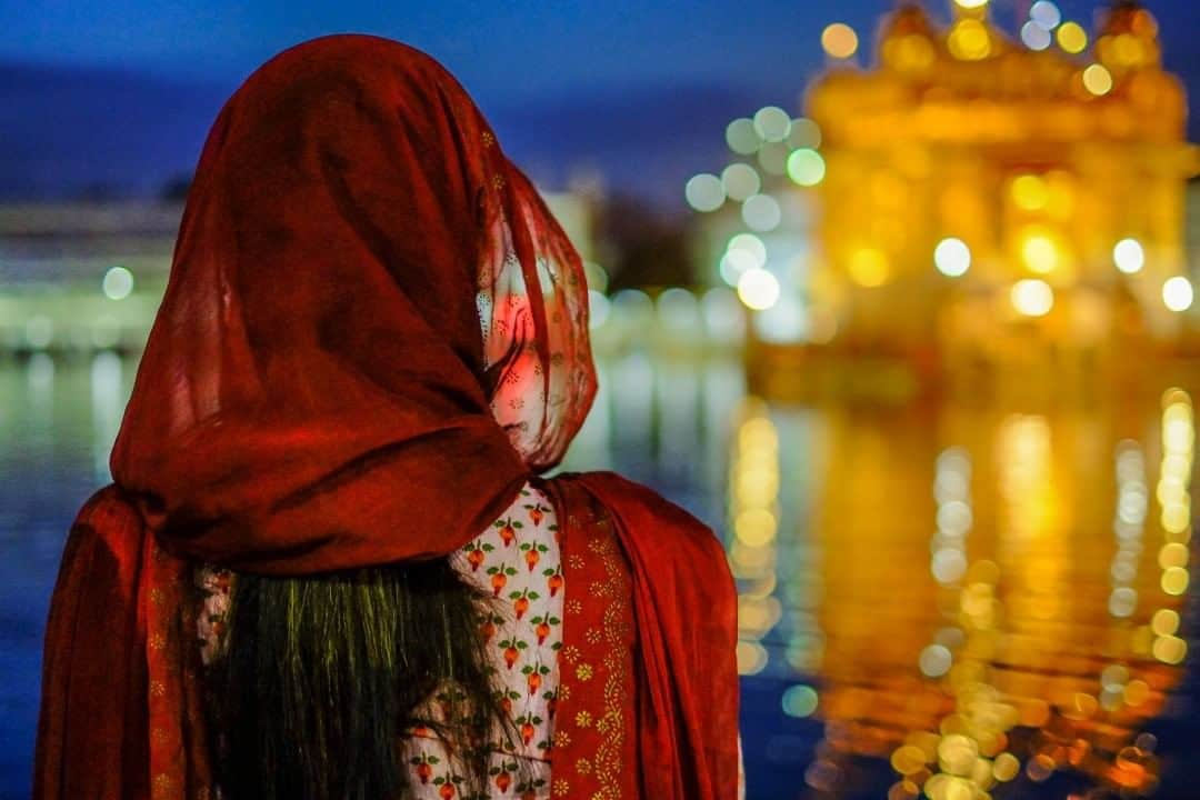 National Geographic Travelさんのインスタグラム写真 - (National Geographic TravelInstagram)「Photo by @francescolastrucci  Built in the middle of a rectangular pool of "amrit" (holy water), which is believed to have healing powers and also gives the name to the city of Amritsar, the Golden Temple glows at twilight as a pilgrim admires its splendor. Also known as Harmandir Sahib, the Golden Temple is the most sacred site in the world for Sikhs. Much of India’s Sikh population lives in the state of Punjab and regularly visits the shrine, while most other Sikhs in India and around the world endeavor to make a pilgrimage here at some point in their lives.  Beyond its high historical and architectural value, the place is fully alive with religious reverence and sacredness. The complex has four entrances oriented according to the four cardinal points to symbolize the belief of the Sikh in equality and to welcome all people regardless of religion or provenance into their holy place to experience one of the most tangibly spiritual places in India. As visitors walk in circles around the marble pavement that surrounds the sacred pool, an enchanting music induces a constant yet delicate state of trance. Pilgrims immerse themselves in the water throughout the day and night. Follow me @francescolastrucci for more places, daily life, and stories around the world. #india #goldentemple #dailylife」7月30日 17時08分 - natgeotravel