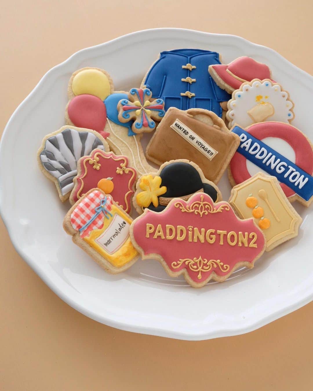 KUNIKAのインスタグラム：「PDDDINGTON 2 cookies 🧸🍊🎪🎈🇬🇧﻿ ﻿ 好きな映画のクッキーを作るシリーズ第3弾。﻿ パディントン2をテーマに作りました🥪﻿ (ヒントだった🍊はマーマレードジャムでした!) ﻿ ロンドンが舞台なので、今回も実際に行ったことのある場所の写真も一緒に。 ﻿ 飛び出す絵本が登場するグルーバーさんのお店はNotting Hill、 泥棒を追いかけるシーンのLittle Venice、 裁判のシーンに一瞬映るGuildhall、 キーワードが隠されているTower Bridgeやセントポール大聖堂、 気球で脱出して見渡すロンドンの夜景、 野外遊園地のHyde park...などなど沢山!🎪﻿ ロンドンはいろんな映画がロケ地として使われているので、観てから行くと街歩きがより楽しくなります。 ﻿ パディントン3が制作中ってニュースも...🤭 実現したらいいな!🧸🧡﻿ ﻿ #artofkunika」