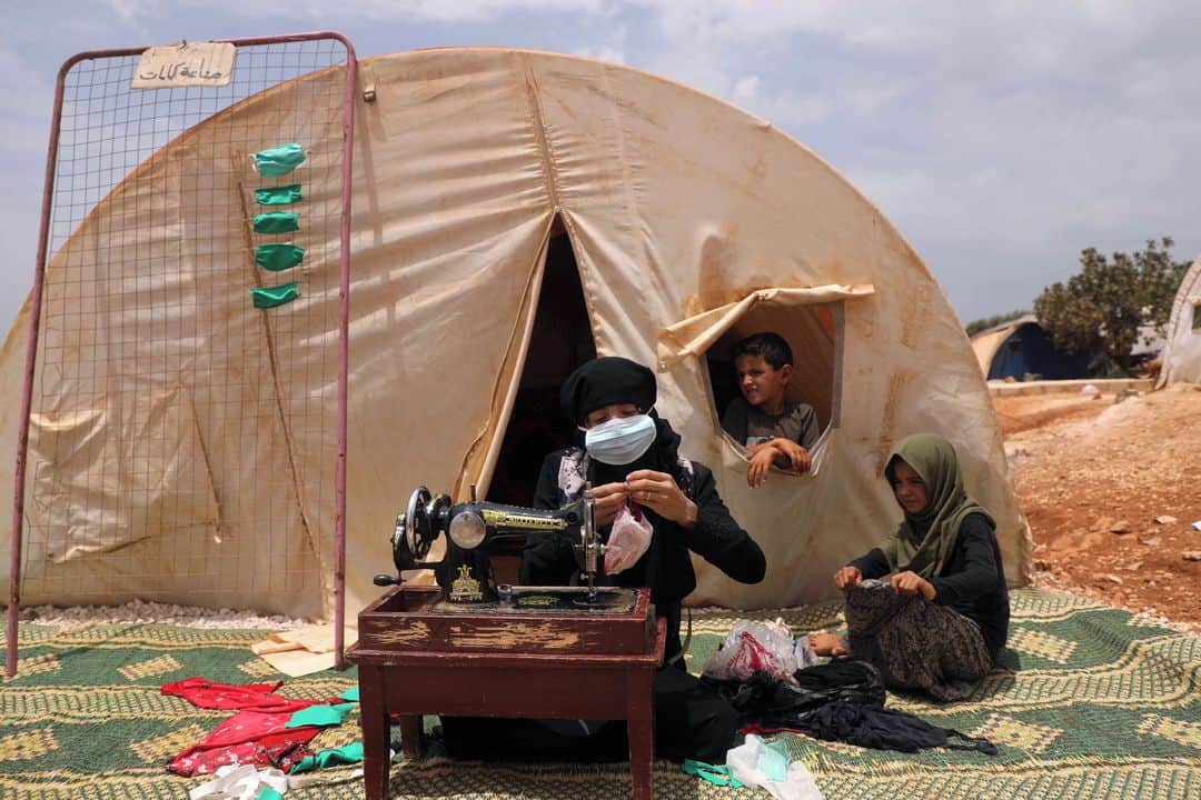 のインスタグラム：「AFP Photo 📷 @aaref_watad - Thirty-years old displaced Syrian woman Umm Hussein sews protective face masks at a camp for the internally displaced people near the town of Maaret Misrin in Syria's northwestern Idlib province on July 27, 2020 amid the COVID-19 pandemic crisis.」