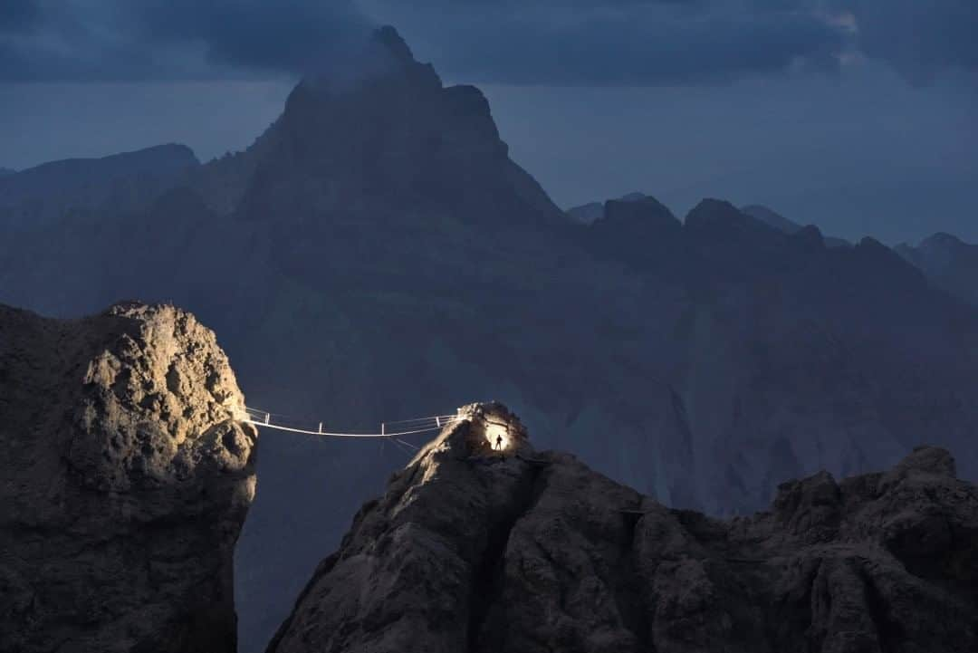 National Geographic Travelさんのインスタグラム写真 - (National Geographic TravelInstagram)「Photo by Robbie Shone @shonephoto  Mountains always remind us how small we really are, especially in the Dolomites. This is the longest suspension bridge in the Dolomites. As climbers and mountaineers we're always looking for perfect blue skies, but the Dolomites often look their best with some clouds breaking up the panorama while the sun rapidly disappears. As the peaks in the distance begin to recede into darkness and the shafts of light become even thinner and weaker, the already extraordinary ambience of this fascinating and beautiful place becomes, for a fleeting moment, even more haunting. The Ivano Dibona via ferrata is a restored historical route used by Italian troops during World War I.」8月1日 5時05分 - natgeotravel