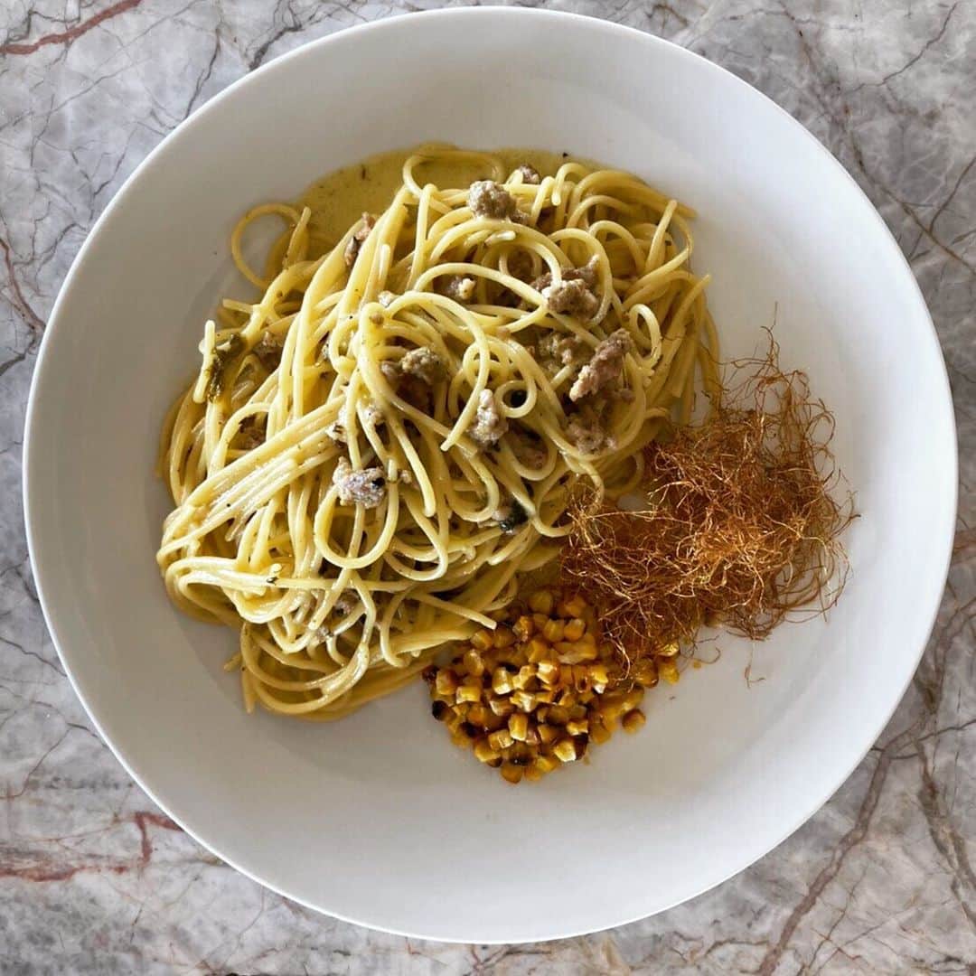 ポジリポのインスタグラム：「今週のピッツァ、パスタのご案内です  〜Weekly Pasta〜 【自家製サルシッチャととうもろこしの燻製カルボナーラ】  炭火で焼いた香ばしいコーンと、パリパリに揚げたとうもろこしのひげ、燻製の香りがするパスタと、それぞれ違う場所に盛り付けてお出しします。 食べるときにお客様自身で組み合わせて食べて頂く事で香ばしいコーンや 燻製の風味が味わえるパスタに仕上げました。  少し変わった面白い一皿です。是非お試しください‼︎ ・ ・ 〜Weekly Pizza〜 【鯖グリル サヤインゲン フィレットのピッツァ】 Pizza Estiva con Fagiolini e Sgombro Grigliato   バカンス真っ盛りのナポリでは食欲がわかないが さっぱりとしたモノを少し食べたい。 そんなイタリア人の夏の定番ピッツァをJUNがposillipo流にアレンジ。 イタリアではカタクチイワシを用いるところですが 日本で美味しい青魚 『鯖』をグリルにしサヤインゲンと合わせました。  ピッツァ生地にバーニャカウダソースを塗ります。 極僅かアンチョビ、鯖のほぐし身、サヤインゲン、バジル、グラナパウダーチーズを散らして焼き上げ、オレガノ、バジル、ニンニクで和えたフレッシュトマトをのせて完成です。  フレッシュなトマトを後のせし軽やかさでバランスの取れたピッツァに‼︎ そしてサヤインゲンだけでなく、鯖の脂とも非常に相性が良いからです。 白ワインがすすむPizzaです。今週末日曜まで‼︎ ・ ・ ※ランチタイムのチョイスでお選びいただけます」