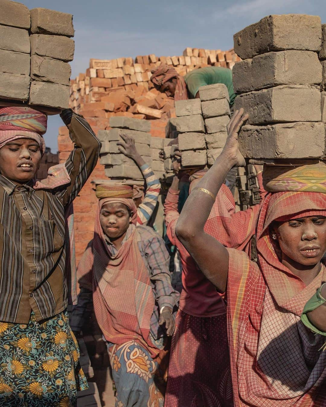 ジョン・スタンメイヤーさんのインスタグラム写真 - (ジョン・スタンメイヤーInstagram)「Every time I see a brick, I remember these strong, sweet ladies by the Brahmaputra River near Dhubri in Assam. All day, six days a week, these amazing women move 200 or more loads of bricks, each a perfectly balanced stack of eight, sometimes nine, weighing about 32 kilograms (70 pounds). Back and forth, they swerve barefoot between each other in painful ballet steps, earning between $2-$4 a day. Before understanding how to photograph labor, I need to do it. Around 190 fewer loads I carried then these gentle giants of strength, quickly I knew this was unhealthy, deeply unpleasant labor. Honestly, it’s barbaric. I understand we want things cheap...microwaves, hairbrushes, socks, and bricks too. It is eternal poverty, lack of opportunity, and inequality that causes millions of women, not only in India, to be carrying the weight of the world upon their heads. The Atlas’s. ⠀⠀⠀⠀⠀⠀⠀⠀ India’s Daunting Challenge: There’s Water Everywhere, And Nowhere - Chapter 8 of the @outofedenwalk, my latest story in the August 2020 issue of @natgeo magazine. ⠀⠀⠀⠀⠀⠀⠀ @natgeo @outofedenwalk #walkingindia #edenwalk #india #dhubri #dhuburi #assam #women #ladies #brickmakers #labor #womenlabor #atlas」8月3日 14時15分 - johnstanmeyer