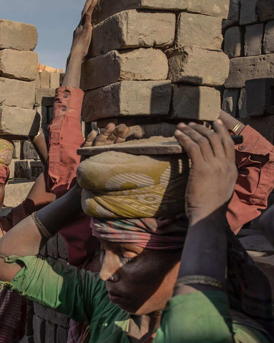 ジョン・スタンメイヤーさんのインスタグラム写真 - (ジョン・スタンメイヤーInstagram)「Every time I see a brick, I remember these strong, sweet ladies by the Brahmaputra River near Dhubri in Assam. All day, six days a week, these amazing women move 200 or more loads of bricks, each a perfectly balanced stack of eight, sometimes nine, weighing about 32 kilograms (70 pounds). Back and forth, they swerve barefoot between each other in painful ballet steps, earning between $2-$4 a day. Before understanding how to photograph labor, I need to do it. Around 190 fewer loads I carried then these gentle giants of strength, quickly I knew this was unhealthy, deeply unpleasant labor. Honestly, it’s barbaric. I understand we want things cheap...microwaves, hairbrushes, socks, and bricks too. It is eternal poverty, lack of opportunity, and inequality that causes millions of women, not only in India, to be carrying the weight of the world upon their heads. The Atlas’s. ⠀⠀⠀⠀⠀⠀⠀⠀ India’s Daunting Challenge: There’s Water Everywhere, And Nowhere - Chapter 8 of the @outofedenwalk, my latest story in the August 2020 issue of @natgeo magazine. ⠀⠀⠀⠀⠀⠀⠀ @natgeo @outofedenwalk #walkingindia #edenwalk #india #dhubri #dhuburi #assam #women #ladies #brickmakers #labor #womenlabor #atlas」8月3日 14時15分 - johnstanmeyer