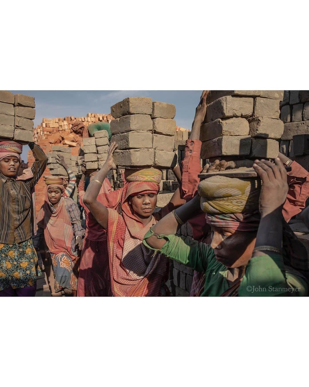 ジョン・スタンメイヤーさんのインスタグラム写真 - (ジョン・スタンメイヤーInstagram)「Every time I see a brick, I remember these strong, sweet ladies by the Brahmaputra River near Dhubri in Assam. All day, six days a week, these amazing women move 200 or more loads of bricks, each a perfectly balanced stack of eight, sometimes nine, weighing about 32 kilograms (70 pounds). Back and forth, they swerve barefoot between each other in painful ballet steps, earning between $2-$4 a day. Before understanding how to photograph labor, I need to do it. Around 190 fewer loads I carried then these gentle giants of strength, quickly I knew this was unhealthy, deeply unpleasant labor. Honestly, it’s barbaric. I understand we want things cheap...microwaves, hairbrushes, socks, and bricks too. It is eternal poverty, lack of opportunity, and inequality that causes millions of women, not only in India, to be carrying the weight of the world upon their heads. The Atlas’s. ⠀⠀⠀⠀⠀⠀⠀⠀ India’s Daunting Challenge: There’s Water Everywhere, And Nowhere - Chapter 8 of the @outofedenwalk, my latest story in the August 2020 issue of @natgeo magazine. ⠀⠀⠀⠀⠀⠀⠀ @natgeo @outofedenwalk #walkingindia #edenwalk #india #dhubri #dhuburi #assam #women #ladies #brickmakers #labor #womenlabor #atlas」8月3日 14時15分 - johnstanmeyer