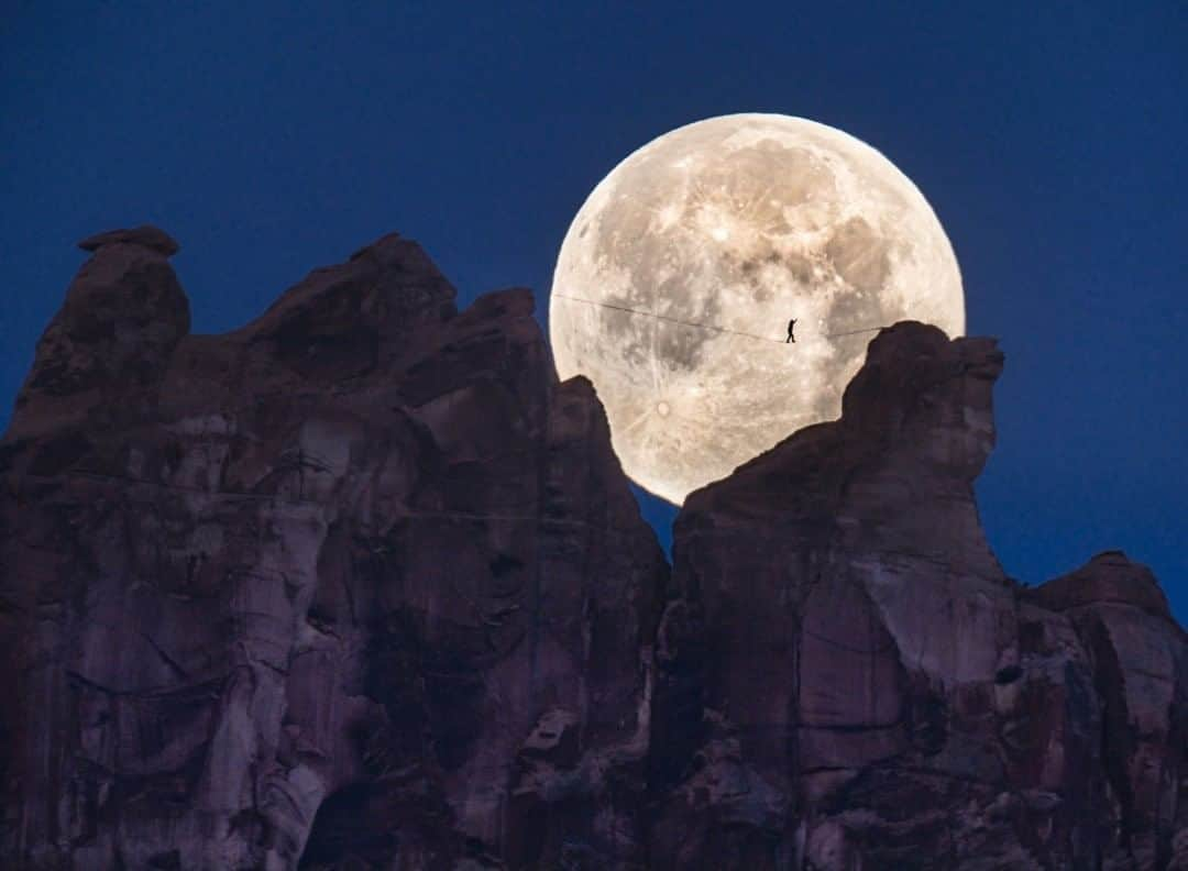 ナショナルジオグラフィックさんのインスタグラム写真 - (ナショナルジオグラフィックInstagram)「Photo by @renan_ozturk  A "moon walk," captured without digital manipulation within a single frame. This is dedicated to our late friend Dean Potter, who first envisioned a free-solo  image like this. Pictured here is Andy Lewis, walking a gap high above the valley floor in Moab, Utah. I shot this image from three km (two miles) away, after navigating cliffy terrain with a huge 600mm lens, which truly pushed my physical capabilities, knowledge of the landscape, and all the technology abused in the process. After questing deep into the wilderness and missing the shot for the moonrise/sunset moment, I stumbled through the night, arriving tired and bloody to the moonset/sunrise location on the opposite side of the towers. This moment of alignment lasted for about one minute and only a few frames. It give me such hope to witness such artistic acts of humanity in these times! See @renan_ozturk for more on the backstory and images from this endeavor. #moonwalk #slackline」8月4日 11時35分 - natgeo