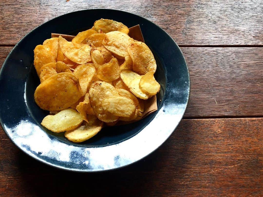 CHIPPRUSONのインスタグラム：「Making potato chips.  最近ハマっているのがポテトチップス作り。天土ORGANICAのじゃがいもをスライスするところから、丁寧に始める。じゃがいもの品種は、ねっちりとした粘り気があるキタアカリより、十勝こがねなど、食感がホロリとサクみのあるものがいいみたい。低温の油の中で、大量のじゃがいもをゆっくりと、水分を抜くように揚げていくと、大体こんな感じになる。天ぷら屋さんの反対をやってみたら、なんだかそれっぽいものが出来た。ヒントは、ポテトチップス工場の現場を想像してみたら出てきた。  油で調理する様子は、ジャム作りと似ている。どちらも、泡で判断すれば間違わない。やりたい事リストにポテチを売る、もつけ加えたいこの頃…」