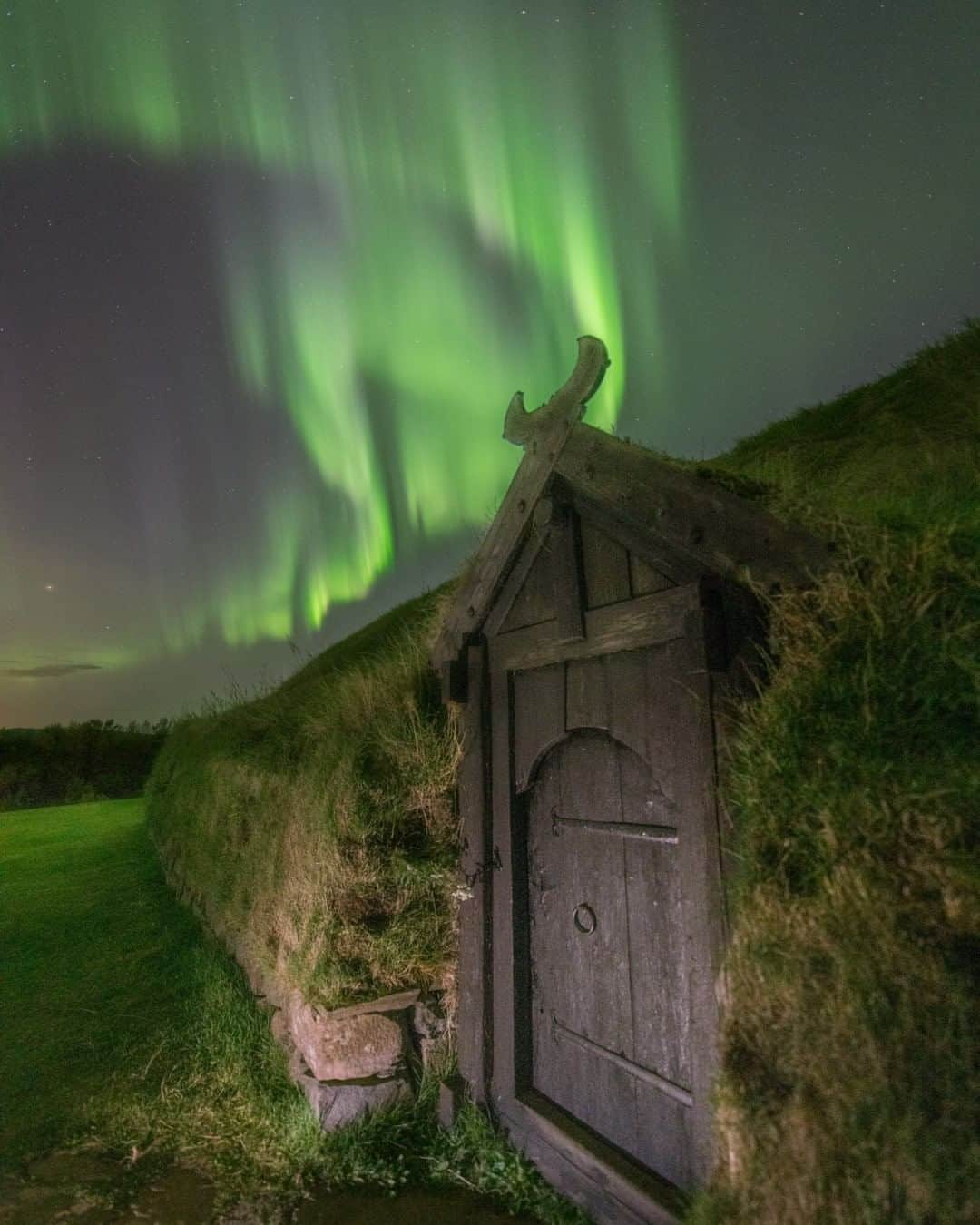 National Geographic Travelさんのインスタグラム写真 - (National Geographic TravelInstagram)「Photo by @babaktafreshi  I felt an incredible connection to the history and culture of this far north land when the dazzling, dancing rays of the aurora borealis appeared over a Viking village on this late September midnight. This is where some of the earliest Nordic settlers lived in Iceland a thousand years ago. They were unaware that a nearby snowcapped mountain was (and remains) an active volcano. In 1104 a massive eruption ended life in the farming village. The replica turf houses were constructed near the original site, based on archaeological findings.⁣  Follow me @babaktafreshi for more visual stories under the stars. #aurora #northernlights #vikings #nordic #twanight」8月5日 19時03分 - natgeotravel