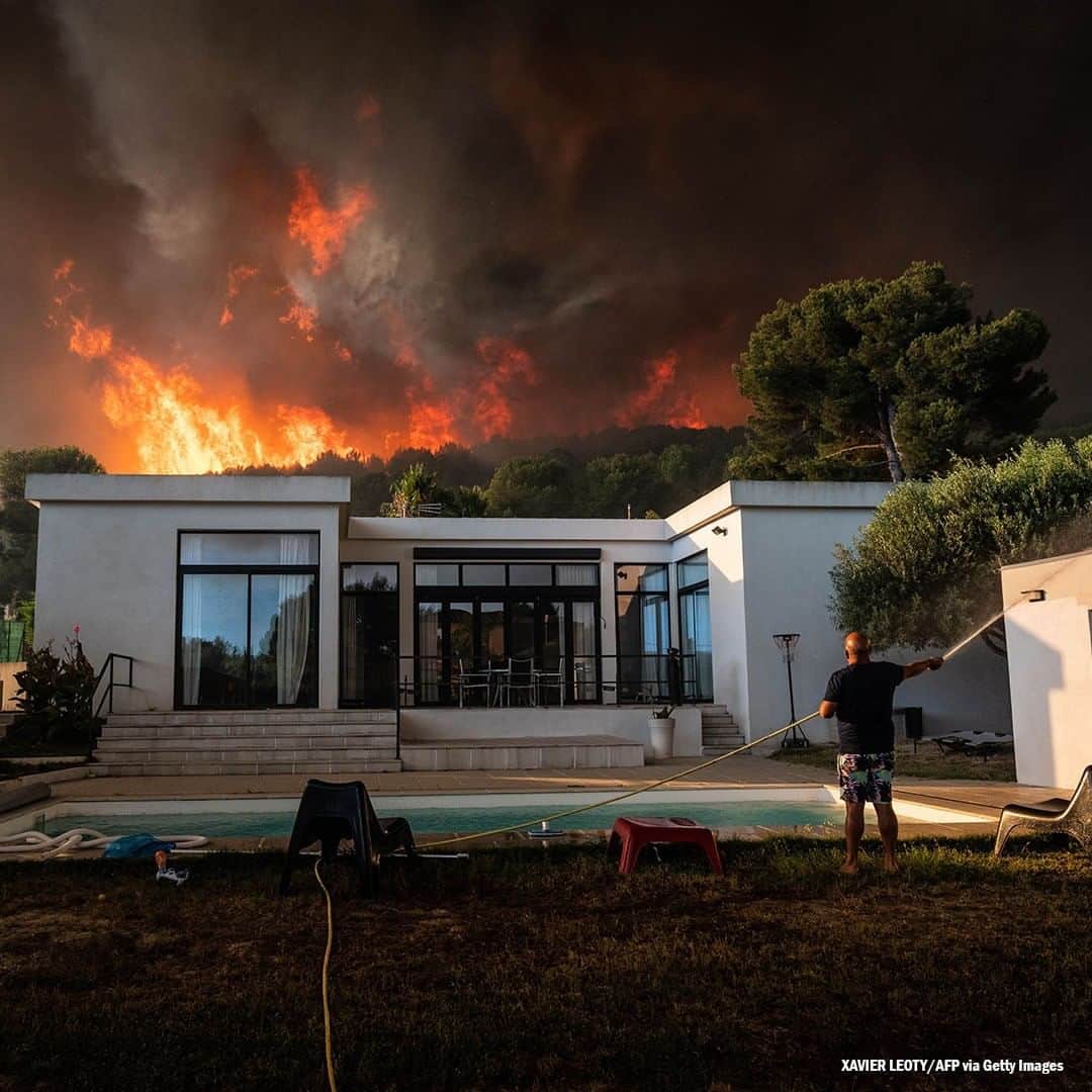 ABC Newsさんのインスタグラム写真 - (ABC NewsInstagram)「A man uses a garden hose to drench his house before being evacuated as a wild fire burns in the background, in La Couronne, near Marseille, France. #france #wildfire」8月5日 19時30分 - abcnews