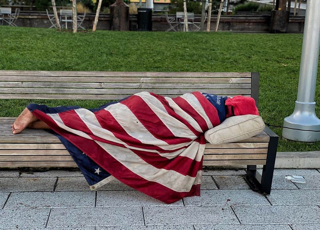 Robert Clarkさんのインスタグラム写真 - (Robert ClarkInstagram)「I saw this lost soul on my 6am walk this morning in Domino Park, Brooklyn. Seeing a homeless man wrapped up in the #AmericanFlag was so surprising that I just froze, I shot one photo and continued along my way. It wasn’t until I was looking for another picture that I saw this on my camera roll. Seems to be a fitting metaphor for the state of our union. #2020」8月6日 8時00分 - robertclarkphoto