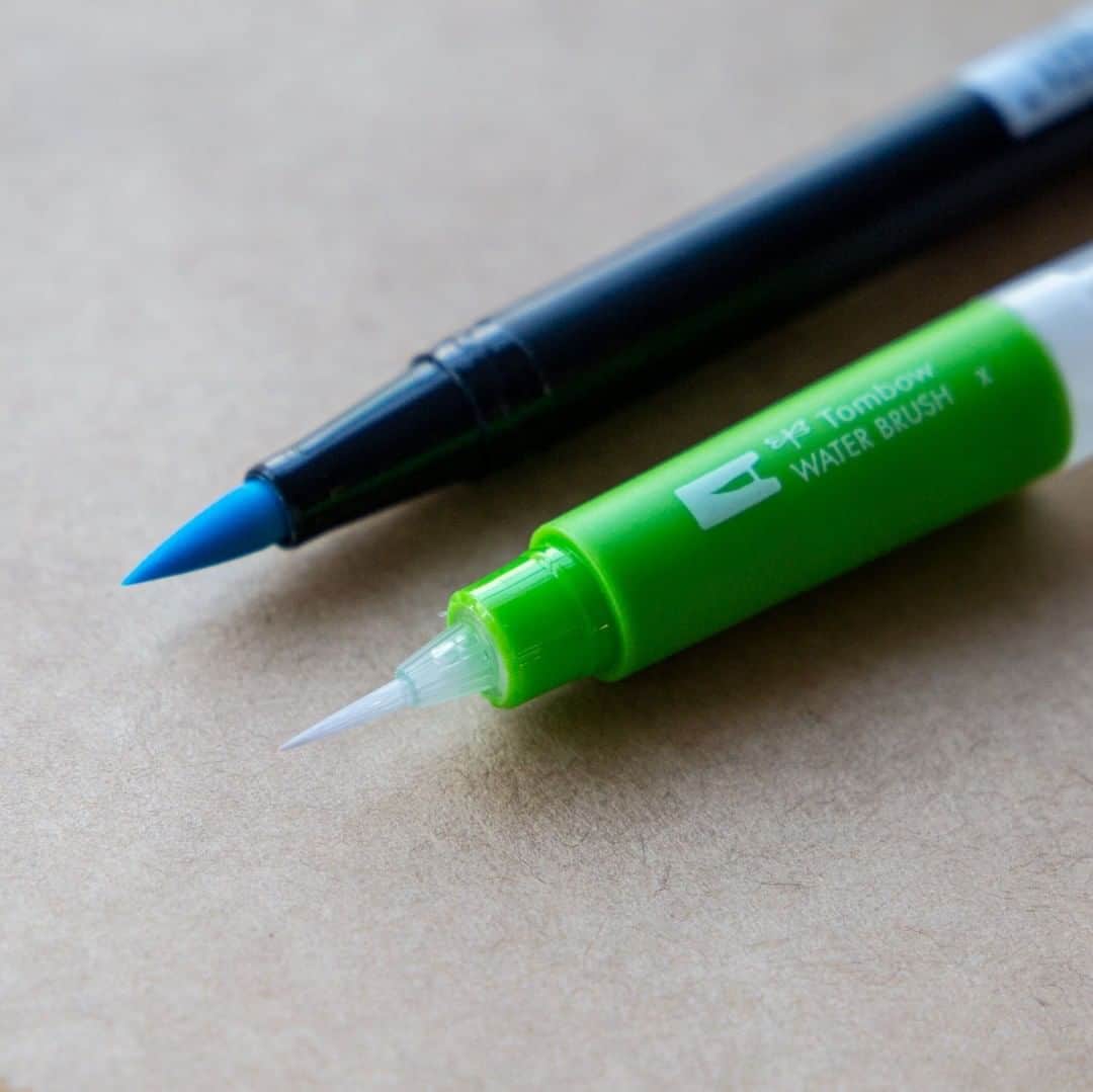トンボ鉛筆さんのインスタグラム写真 - (トンボ鉛筆Instagram)「ABTと一緒に使いたい「水筆」のご紹介📖 水性染料インクのABTは水筆と一緒に使うことで水彩表現も楽しめます。 トンボの水筆は全部で３種類で、穂先のサイズ感が伝わるようにABTと比べてみました！ 上段の「細筆」は力の入れ具合によって極細～細めの線が描けます。小さなモチーフイラストを描く際や描き込みにも向いています。 真ん中の「中筆」は色々なシーンで活躍するので、迷ったらまずはこれ！穂先を使って細かく塗ることも、筆全体で広い面積を塗ることもできます。 下段の「平筆」は広い部分を一気に塗りたいときや、線の幅を均一に塗る時などに活躍します。  キャップ付きなのでペンケースに入れて持ち運びもできます。キャップはペンに取り付けられるのでなくさず、作業場でも邪魔になりません。 水を入れる入れ口が広いところもうれしいです☺️ 昨日ご紹介した「ABT６色セット」も水筆と一緒に使えばもっと楽しめます🌷 . . . #watercolor #watercolorpainting #tombowwaterbrush #tombowwaterbrushpen #トンボ水筆 #水筆 #水彩画イラスト #tombowdualbrushpens #tombowabt #watercolor_art #水彩」8月6日 20時02分 - tombowpencil