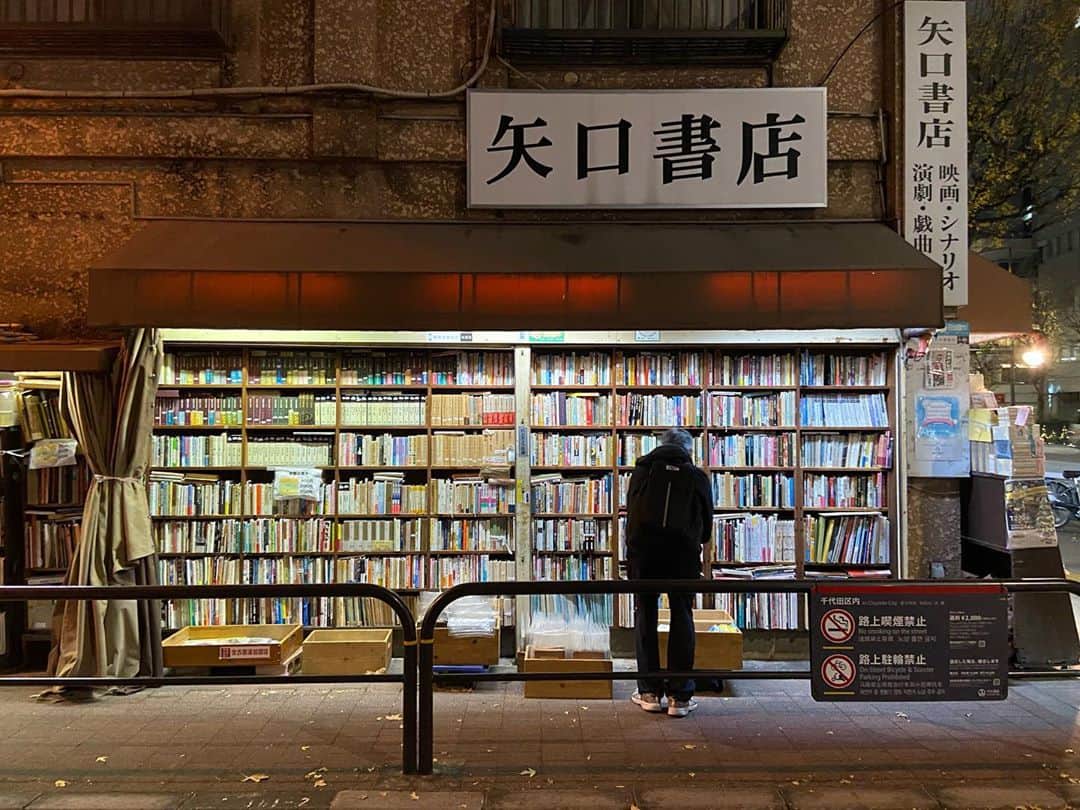 ケンゾーミナミのインスタグラム：「Jimbocho in December 2019. It’s the one of my most favorite neighborhoods in the world. It’s the area full of booksellers of every specific kinds you can think of, block after block, the building after building full of them from the top to the bottom. (This is the side of Yaguchi Bookstore which specializes in film and theater related printed matters, scripts, etc since 1918.) This setting here seems to be the ideal condition for book shopping at the moment in pandemic...)  I miss bookstores.」