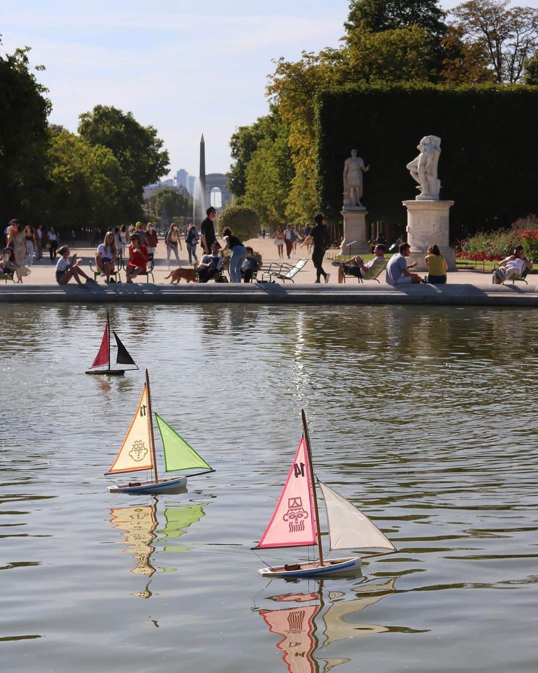 のインスタグラム：「.  🇫🇷 Venez perpétuer la tradition ! ⛲ - ⛵ Le Grand Bassin rond du jardin des Tuileries accueille une magnifique flotte de petits bateaux à voile de toutes les couleurs ! Équipés d’un bâton, les enfants peuvent s’amuser librement autour du bassin pour organiser la navigation de leur petit voilier, comme le veut la tradition du 17è siècle ! - 👀 Reconnaissez-vous certaines œuvres du Louvre sur les voiles ? 😃 - 📍 Pour jouer avec @les_petits_bateaux_tuileries, rendez-vous au Grand Bassin rond, dans l’allée centrale du jardin ! - 📆 Ouvert 7j/7 de 11h à 18h pendant les vacances, puis le mercredi de 13h à 18h et le samedi et dimanche de 11h à 18h à partir de septembre. - - - - 🌎 Come and perpetuate the tradition! ⛲️ - ⛵ The round Grand Bassin pond of the Tuileries garden welcomes a magnificent fleet of small colored sailing boats! Equipped with a stick, children can play freely around the basin to organize the navigation of their little sailboat, as is the tradition of the 17th century! - 👀 Do you recognize some of the works of the Louvre on the sails? 😃 - 📍 To play with @les_petits_bateaux_tuileries, come to the Grand Bassin, in the central alley of the garden! - 📆 Open every day from 11am to 6pm in August, then on Wednesday from 1pm to 6pm and Saturday and Sunday from 11am to 6pm from September. -  📸 © Musée du Louvre / Maëlys Feunteun .  .  #Louvre #MuséeDuLouvre」