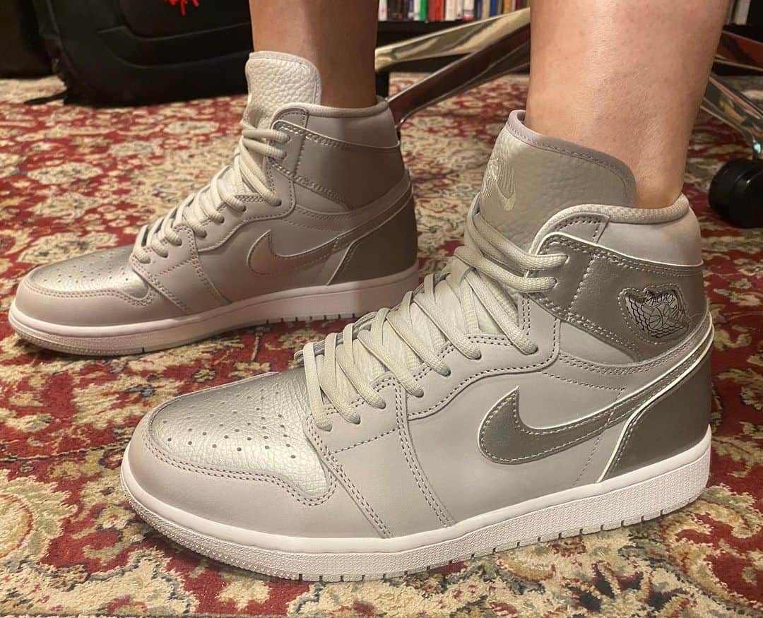 のインスタグラム：「・ ・ そこそこ煮詰まってきたので、休憩に今日到着した  NIKE AIR JORDAN1 "CO JP"の撮影タイム。    まず今までのAJ1に比べて皮が格段に上質。  シボ皮のシュータンといい、ヌバックの質感がしっかりしてて、  ジュエル仕様のウイングロゴやオーバルシューレースの感じも  ちょっと普段のAJ1よりしっかりめ。   ただそのしっかりめの質感ゆえ、  ちょっと普段のサイズ感よりかなりキツめの印象で、  もしかしたら履き始めは結構辛いかもと予測。  気にせず履くにはちょっと時間が掛かるかもなあ。   あとヌバックが普段より上質なのと、  ウイングロゴがジュエル加工なので、  普通にCrep(スニーカー用防水スプレーの定番)かけると  質感変わりそうで少し躊躇。  ドラフティングテープ買って、  ウイングロゴに貼ってからスプレーするのはマストとして、  これ普通に3回かけとかでスプレーして良いのかなあと  少し怯えてます…   あ、見た目と装着感は言わずもがな。  銀で派手かと思いつつ、全然何でも合わせられやすそう。  これはNIKE BY YOUで作った  "Air Dior"のコピーと同じ感覚であちこち履けるかも。  強烈に狙ってたわけではないけど、いい買い物しました。  #nikeairjordan1 #airjordan1 #airjordan1cojp #nikeairjordan1cojp #nike #sneakers #スニーカー #clammbon #クラムボン #ミト #ミトムボン」