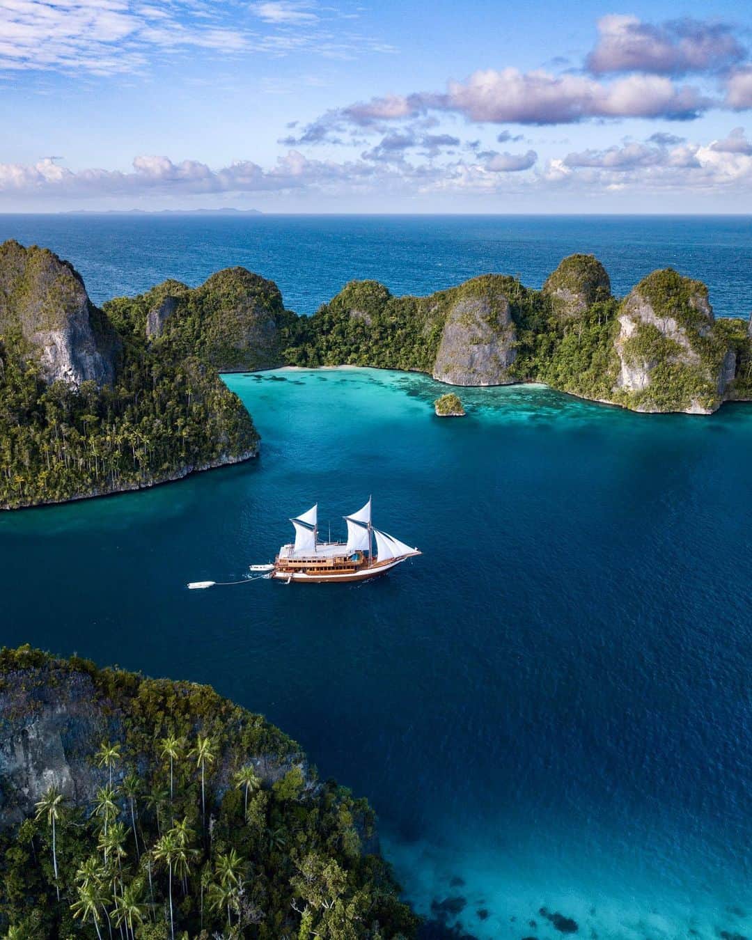 Travis Burkeのインスタグラム：「In the middle of the night, I would find myself scaling up the flimsy rope ladders, holding on for dear life, as the boat sometimes swayed back and forth relentlessly from the large rolling waves deep at sea. After reaching the tiny crow’s nest platform above the sails, I would try and lock my leg or arm onto something (so I wouldn’t fall into the depths of the ocean if I fell asleep) and I would spend hours looking up at one of the best views I have ever seen of the Milky Way Galaxy.  At first I was frustrated that I couldn’t get my camera out to capture the stars because we were on a moving boat, but I ended up loving those simple nights alone, with no cell service, looking up at stars and planets while sailing through one of the most beautiful destinations in the world.  Reminiscing on an incredible “work trip” with the tourism of Indonesia.」