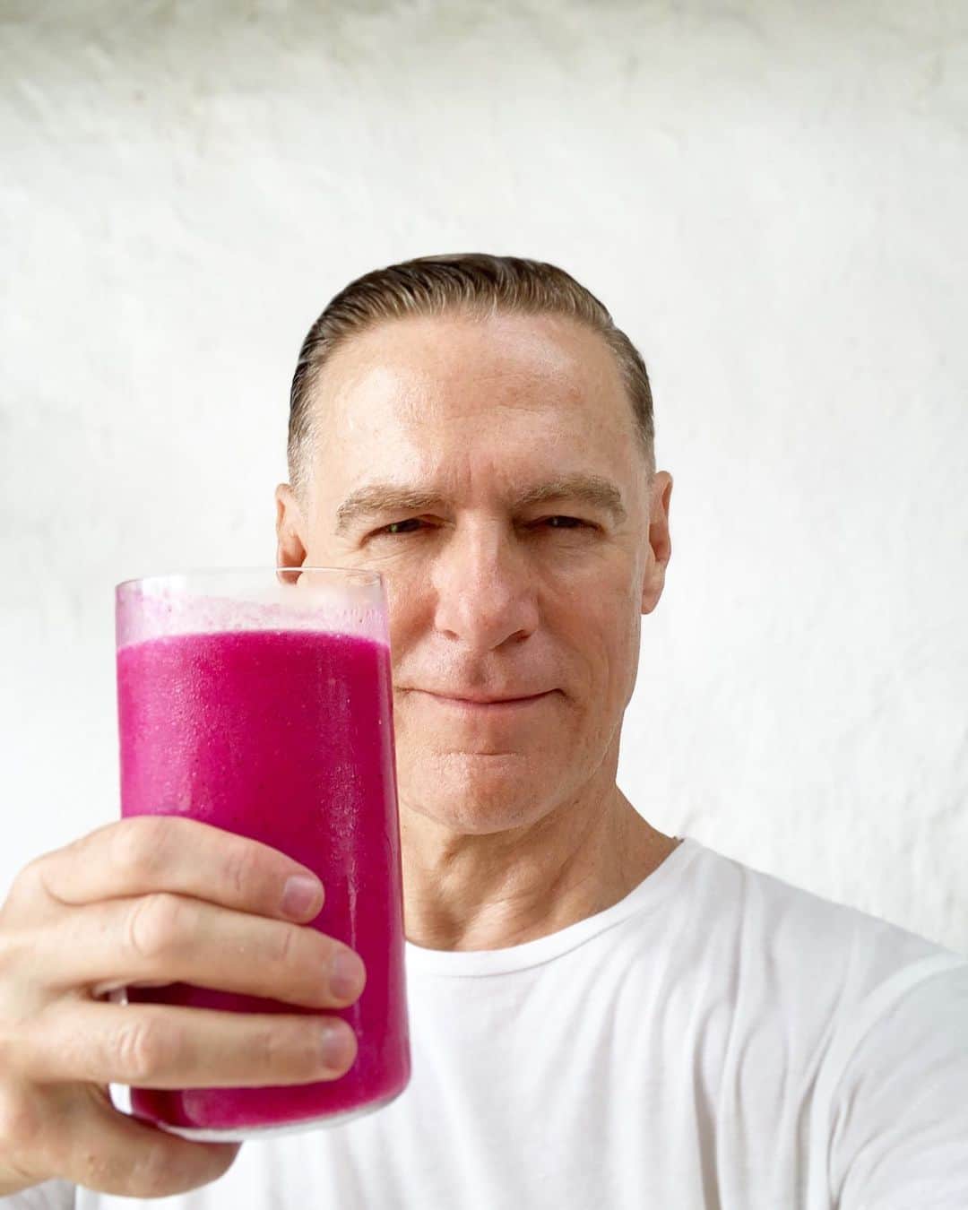 ブライアン・アダムスのインスタグラム：「Straight out of the shower, into a fresh juice. If you follow this account you all know i like to occasionally tip my hat to the vegan world, and fruit is probably the best thing you can give yourself. I know many people can’t afford fancy fruit every day, but apples, bananas and oranges are wonderful and are a great combination, especially if juiced with some fresh ginger root. I start everyday with some sort of fruit. Forget about cartons of pasteurised juice that’s been boiled and has ‘added’ vitamins (added because they nuked the real ones out of it). Go fresh and see for yourself. This beautiful juice is a combination of red dragon fruit, mango, lime, banana, ginger, turmeric and papaya. It’s so delicious, it’s meal unto itself. Don’t be swayed by people that tell you the sugar content is too high in fruit, it’s not sugar it’s fructose and if you eat and drink fruit on an empty stomach (that is the key) you can easily assimilate it. Fruit is a natural detox cleanser for your system, great for your liver and kidneys and helps to build cells. Ok, end of rant, I don’t want to get into trouble! #vegan #veganbreakfast #smoothie #veganbodybuilding 🌱 #ilooklikeatoad」