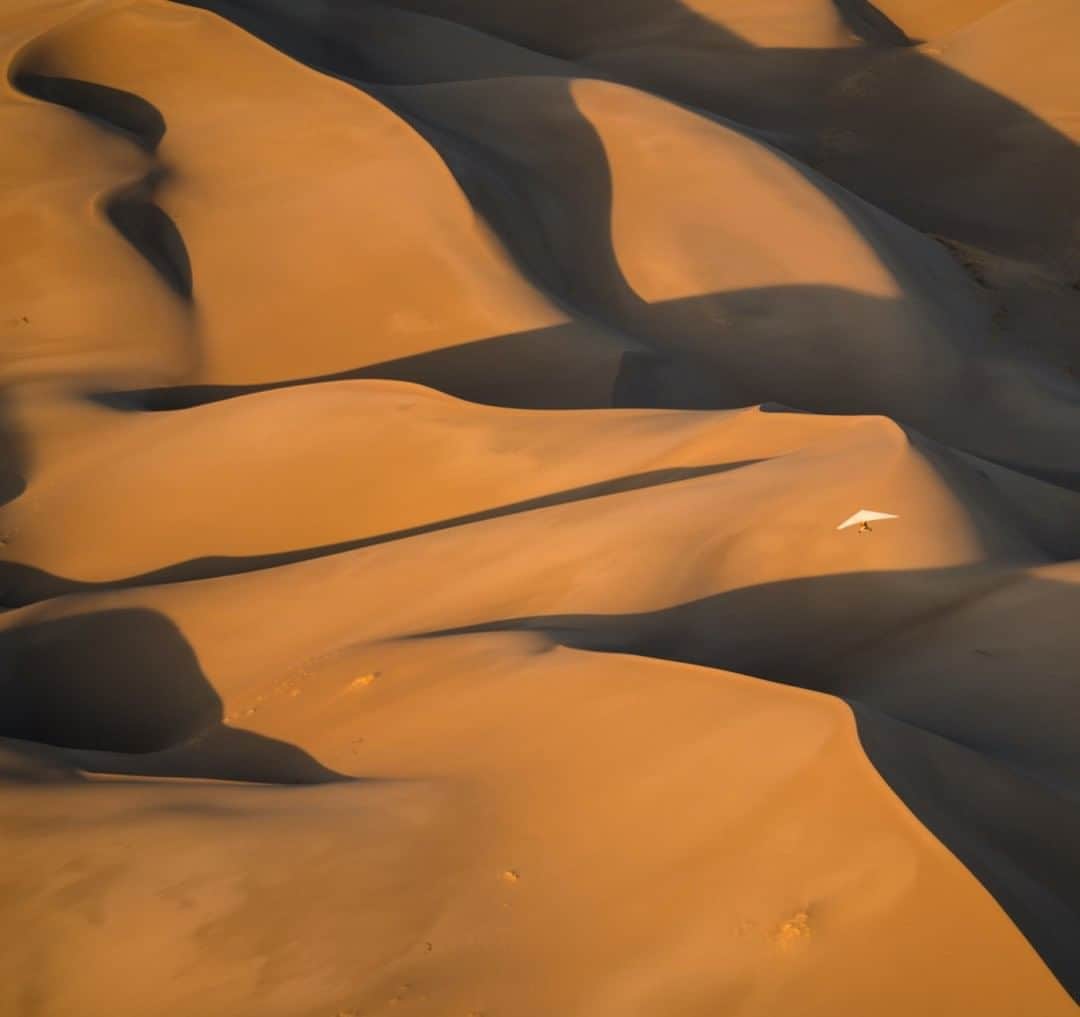 National Geographic Travelさんのインスタグラム写真 - (National Geographic TravelInstagram)「Photo by @chrisburkard  Many people think that you have to travel to exotic locations to find massive desert landscapes that can produce images like this one. While the Sahara, Dubai, and Peru offer some amazing mountains of sand, you can find great deserts here in the United States. This shot is from Colorado's Great Sand Dunes National Park, which contains the tallest sand dunes in North America. The dunes cover a massive area once occupied by lakes. Eventually the lakes receded, allowing sediment to fill the area. Winds blew in sand from the surrounding area over thousands of years, creating these massive dunes. In this image, a small experimental aircraft is compressed into the dune field below from 4,000 feet (1,219 meters) above the ground. That gives you a sense of how large these dunes truly are.」8月12日 7時02分 - natgeotravel