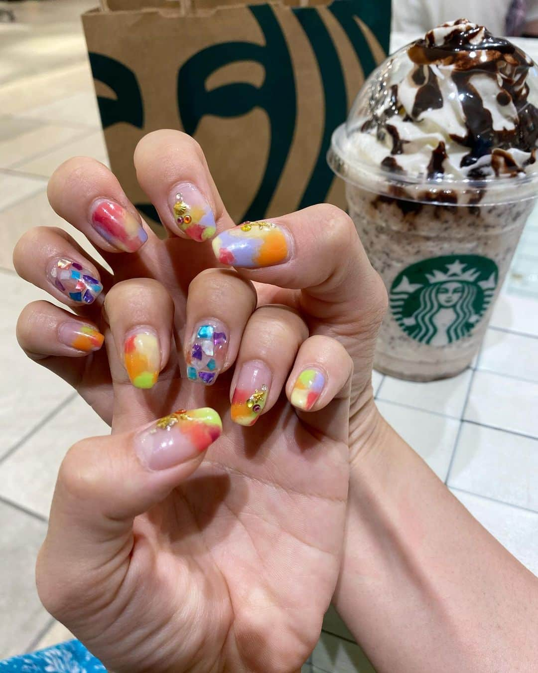 細越麻未（ami）のインスタグラム：「. new nail #nyasnail オーダーしたのとは少し違うけど コレはこれで好き🌈 カラフルで気分もあがる〜 . 最近は… #スタバカスタム　にハマってる〜 オススメな、スタバカスタムとか あれば教えて下さい。 amiは、オレオ風フラペチーノが 好きすぎてこればかり…🤤 . バニラクリームフラペチーノ注文 ・チョコチップ追加+50えん ・チョコチップ増量 ・ホワイトモカシロップに変更 ・チョコソース追加 ・ホイップとチョコソース増量 カロリーもupupするので 気をつけなきゃなドリンク。笑 . #ネイル　#ネイルデザイン #夏ネイル #スクエアネイル #カラフルネイル　#シェルネイル」