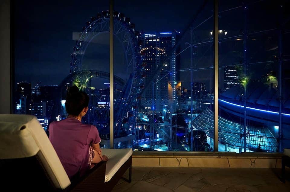 スパ ラクーア公式のインスタグラム：「. ／ 夜のスパは別の顔🌙 夕暮れからはじまる「オトナの自由時間」を✨ ＼ . スパ ラクーアは、昼と夜で雰囲気がガラッと変わります。 日中の混雑も落ち着く18:00以降は、18歳以上のお客様だけの時間帯🌃 #東京ドームシティ の夕暮れや夜景を眺めながら、広々とした空間でゆったりとお過ごしいただけますよ。オトナの“ひとり時間”を楽しむのにも、夜のスパはおすすめです。 . 人気の #ヒーリングバーデ も、夜はライトアップされてエキゾチックなムードに🌴まるで静かなプライベートリゾートにいるような、夜ならではの非日常感をお楽しみください。 . 温泉や岩盤浴で疲れを癒したあとに、「THE BAR」で特別な一杯はいかがですか？ 夜の時間帯には一流ホテル出身のバーテンダーがカウンターに立つこともある、スパ館内の隠れた本格派🍸 いい気分になったらそのまま、リラクゼーションスペースなどで朝までお休みいただくこともできますよ！ . #猛暑 の昼間はやり過ごして、夕暮れを合図に“夜スパ”へどうぞ🌃 東京の夏を潤す、オトナのためのオアシスです✨ . #スパラクーア #スパ #ラクーア #温泉 #サウナ #岩盤浴 #癒し #リラックス #夏 #夏休み #お盆休み #小旅行 #非日常 #バカンス #旅行気分 #おひとりさま #夜スパ #夜景  #心にも潤いを」