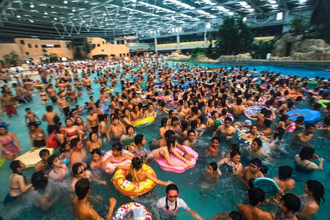 National Geographic Travelさんのインスタグラム写真 - (National Geographic TravelInstagram)「Photos by Michael Yamashita @yamashitaphoto  Summer in the city, Tokyo, Japan  There's no question that given the heat, humidity, and population of Tokyo in the summer, the throngs at any swimming pool there are going to test the limits of crowd control and sanitation. Japan, however, is prepared for this and manages to keep everyone happy and cool—no matter how jam-packed the pool—by moving the water rather than the swimmers.  While not exactly conducive to laps, giant wave pools surge with swells a meter or higher, drenching stationary bathers so they don't need to swim to cool off. Other pools feature circular courses with a current that keeps everyone moving together in the same, very orderly, direction. Japanese people, by tradition and habit, are among the most cleanliness-conscious in the world. The water in these pools is clean enough to drink!  These photographs were taken in 2001. Though closed at the onset of the COVID-19 pandemic, water parks reopened on July 13 with limited reserved admission, health checks, social distancing, and mandatory masks for patrons and staff, as well as detailed instructions in coughing etiquette. #waterpark  #tokyosummer #summertime」9月7日 21時03分 - natgeotravel